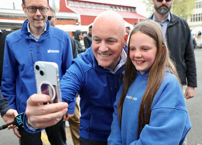 National leader Christopher Luxon takes a selfie with Jayde Butturini, 12, at the riverside...