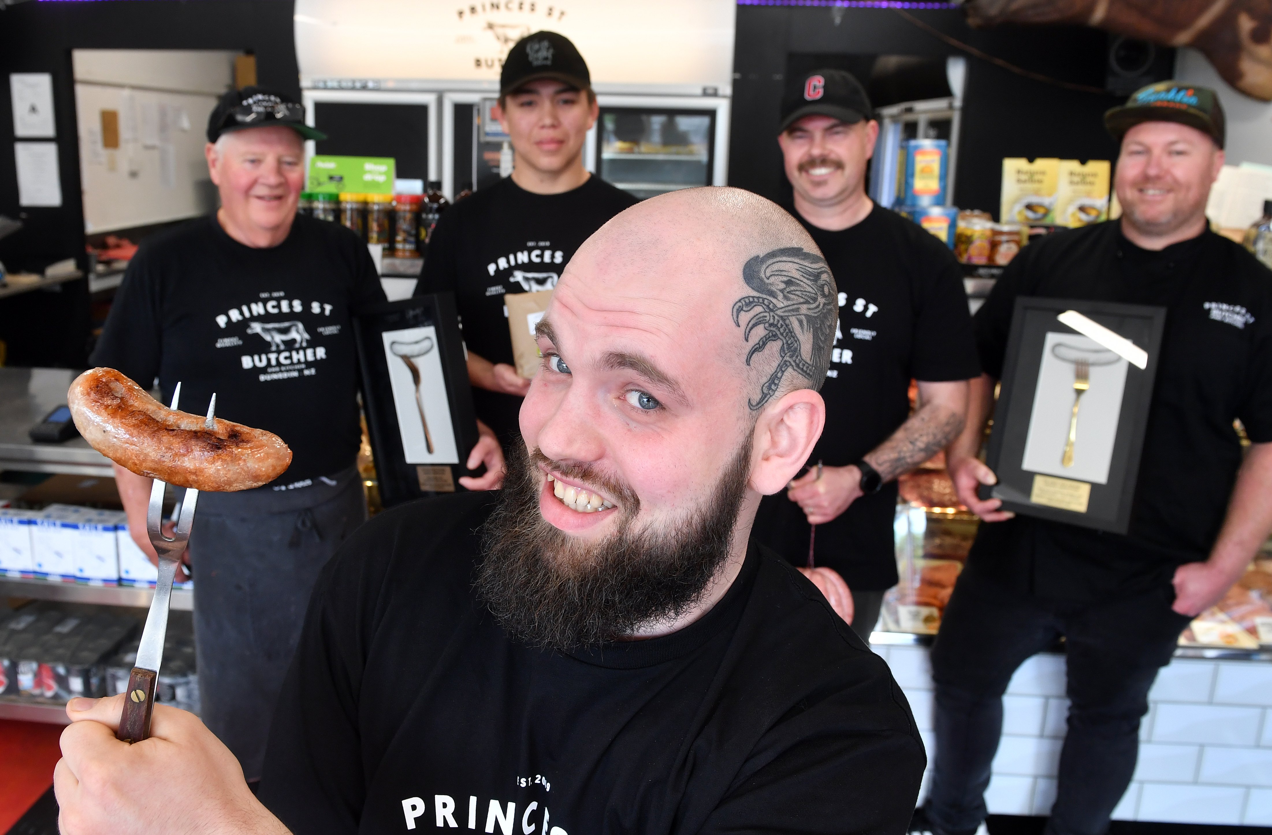 Gourmet assistant Rowan Hoesch holds one of the handmade pork sausages which won gold at the...