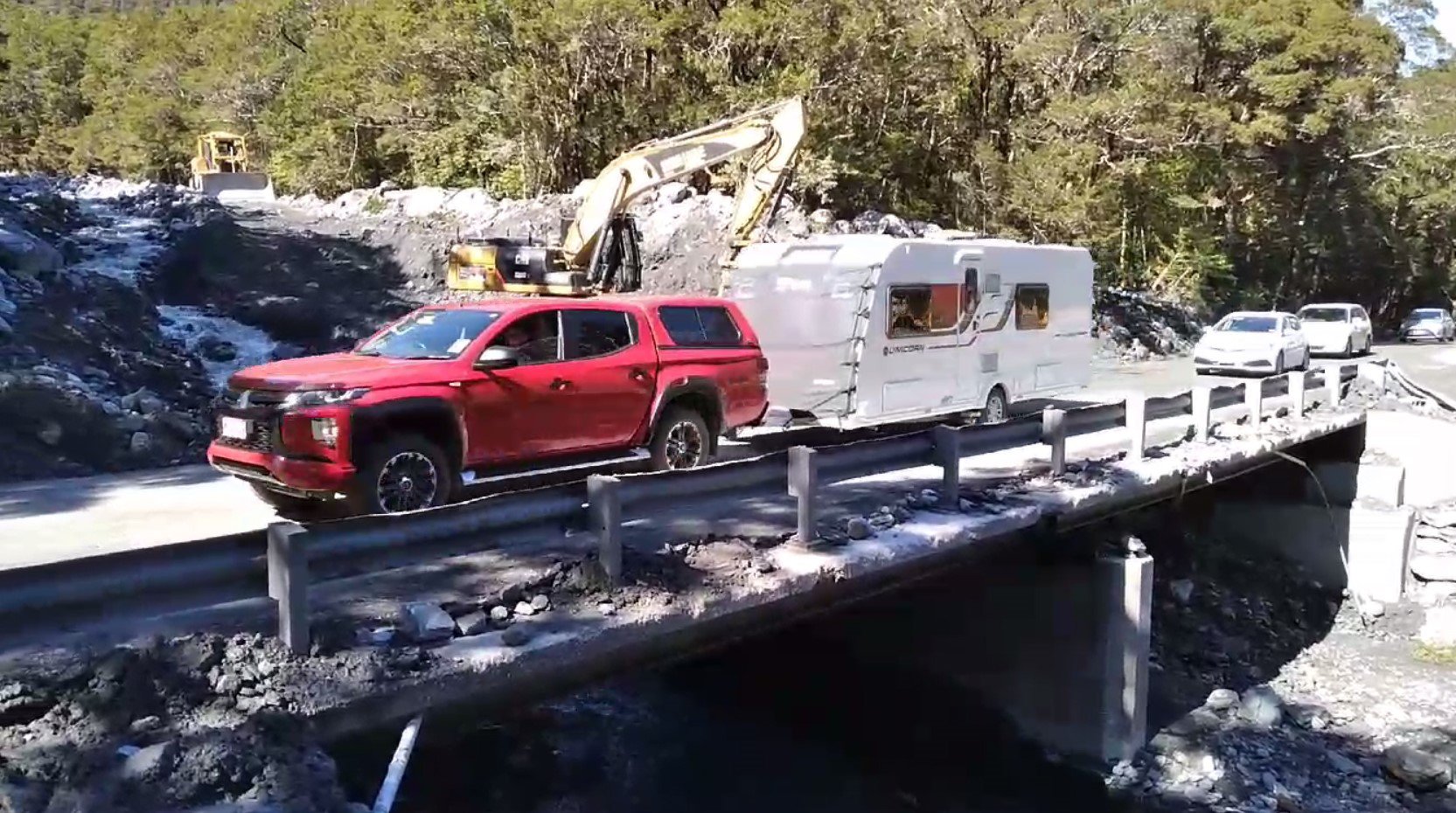 Cars and caravans in yesterday’s noon convoy across Muddy Creek bridge on State Highway 6, which...