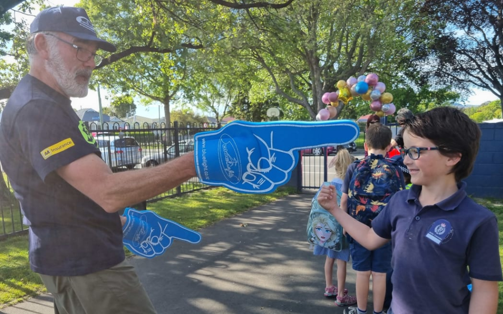 Jeffrey Martin from the New Zealand Police gives a high five welcome to Year Four student Alfonso...