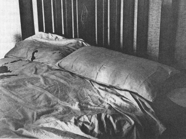 A police photograph of the bed where Donald was shot. There is blood on the bedclothes on his...