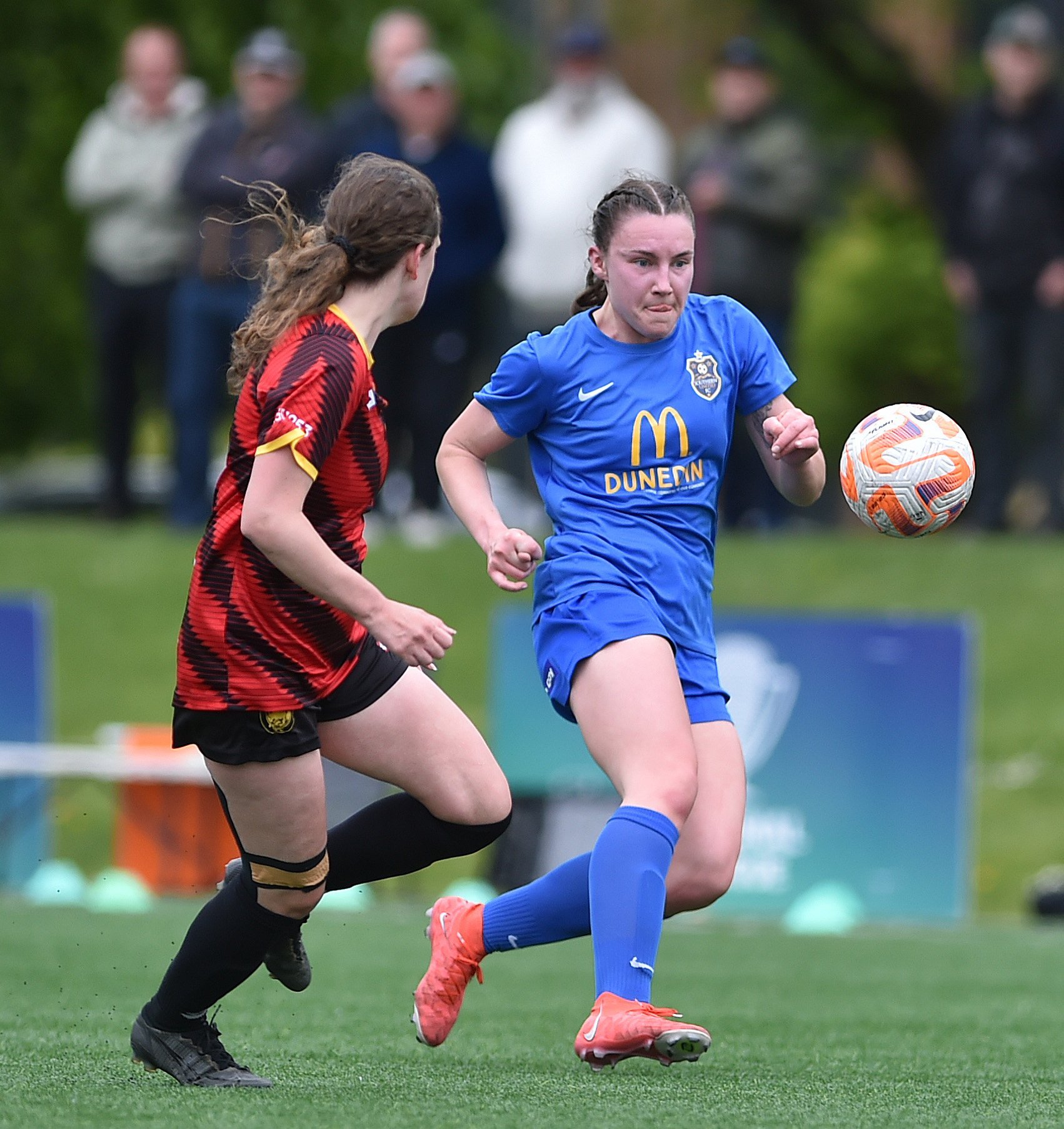 Southern United wing-back Freya Partridge-Moore taps the ball on under pressure from Ellerslie...