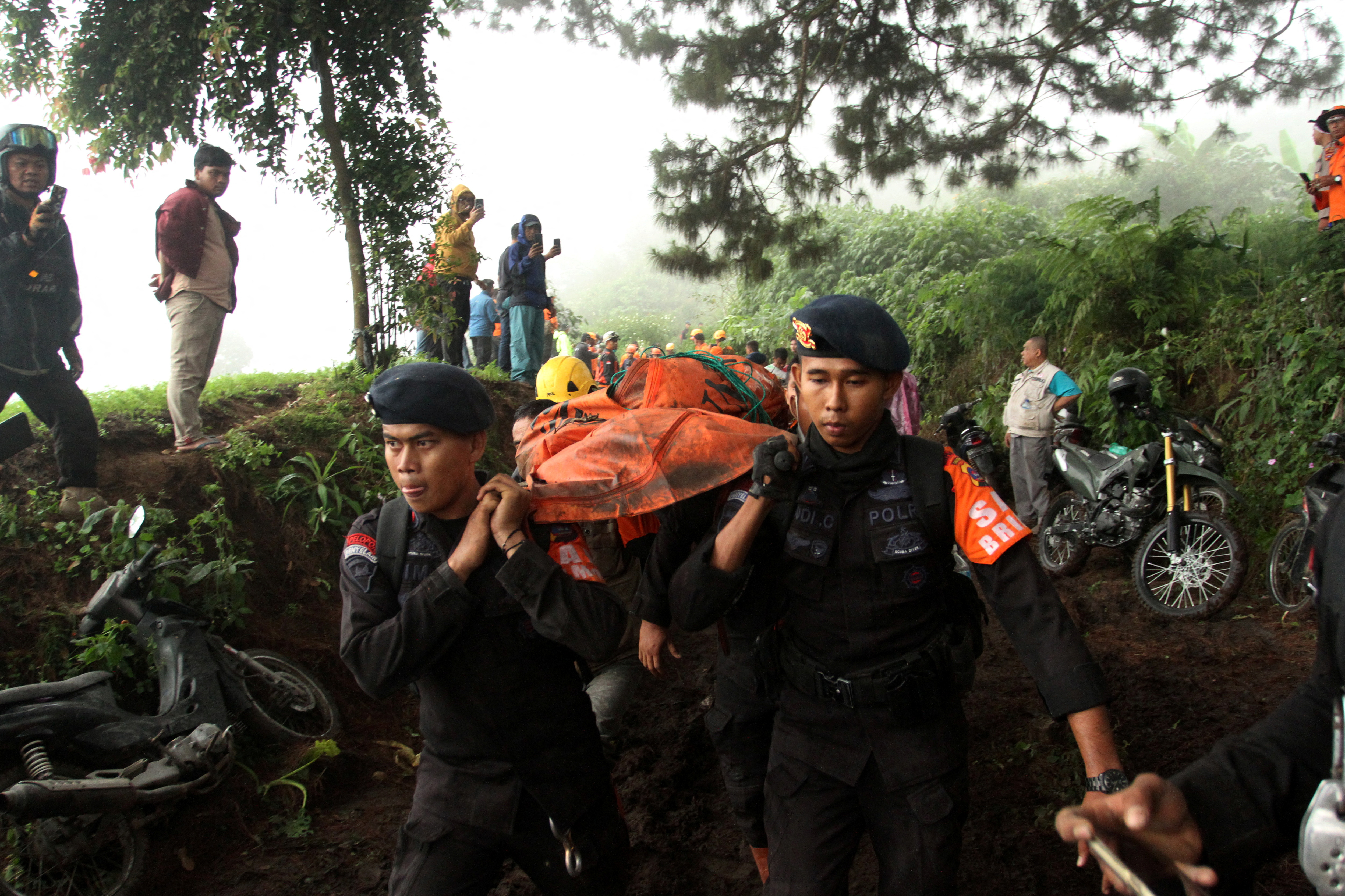 Police carry the body of a person killed in the eruption in West Sumatra province on Tuesday....