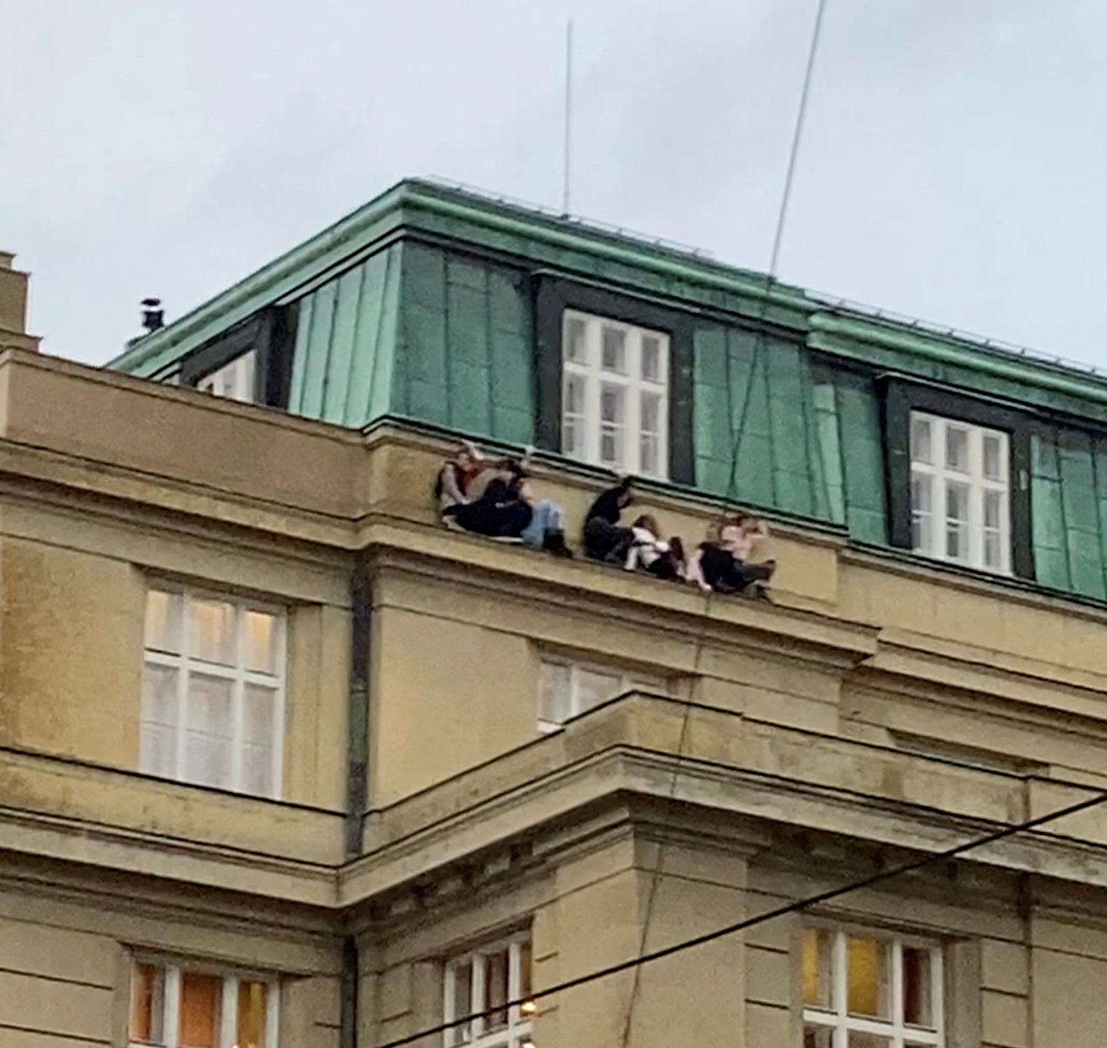 People shelter on a roof during a shooting in one of the buildings of Charles University, in...