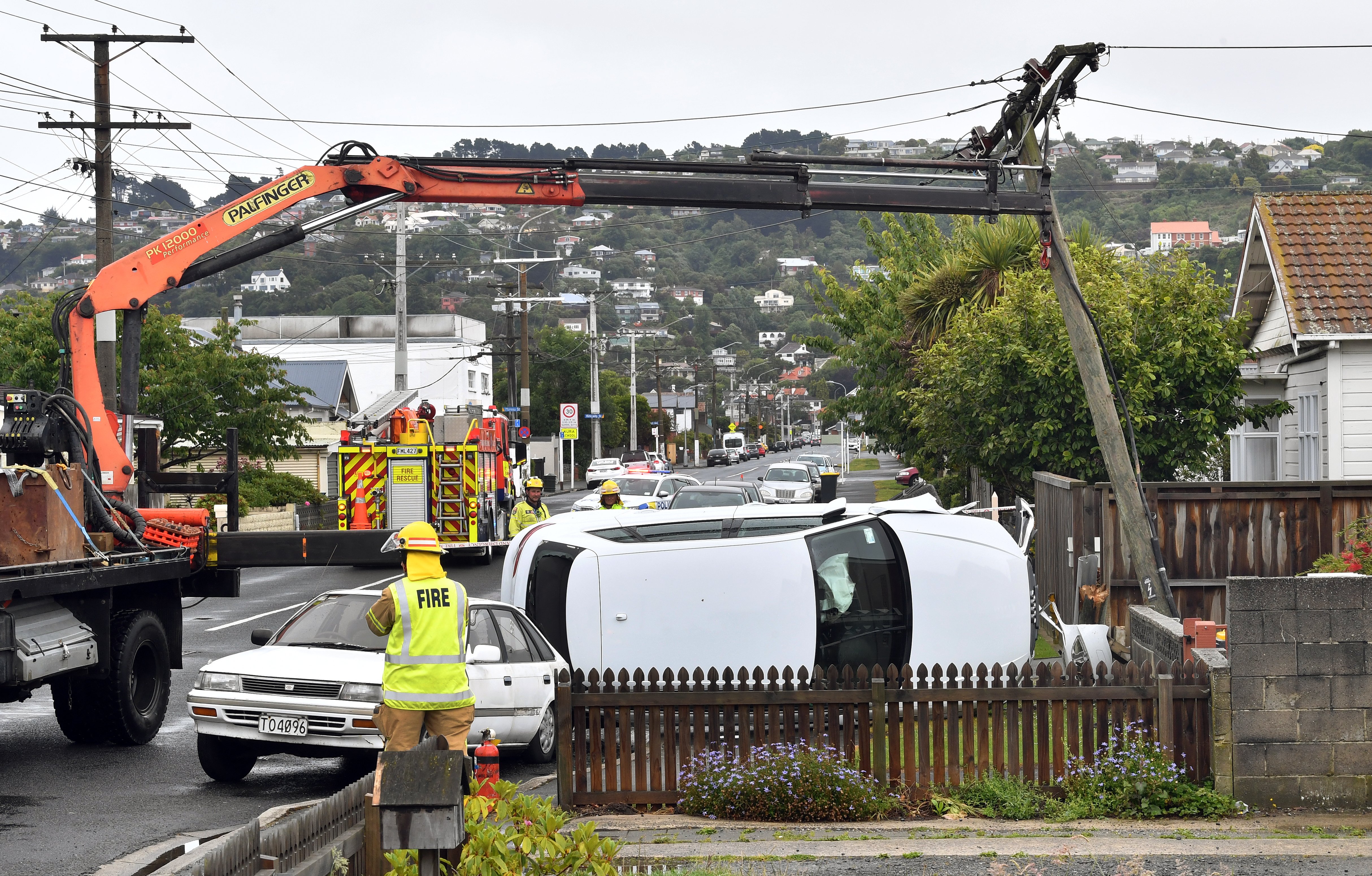 A small crane is used to stabilise a power pole in Bay View Rd yesterday after it was struck by a...