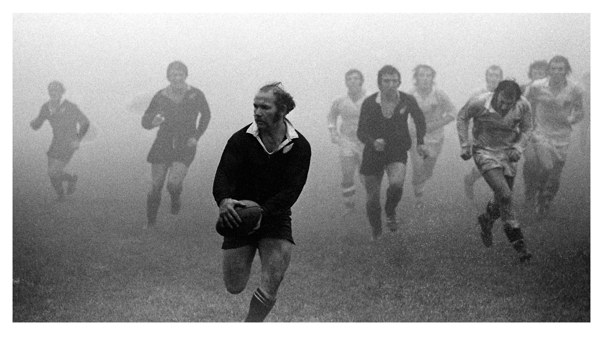 One of Bush's most famous images - All Blacks halfback Sid Going leads the charge of ghost-like...