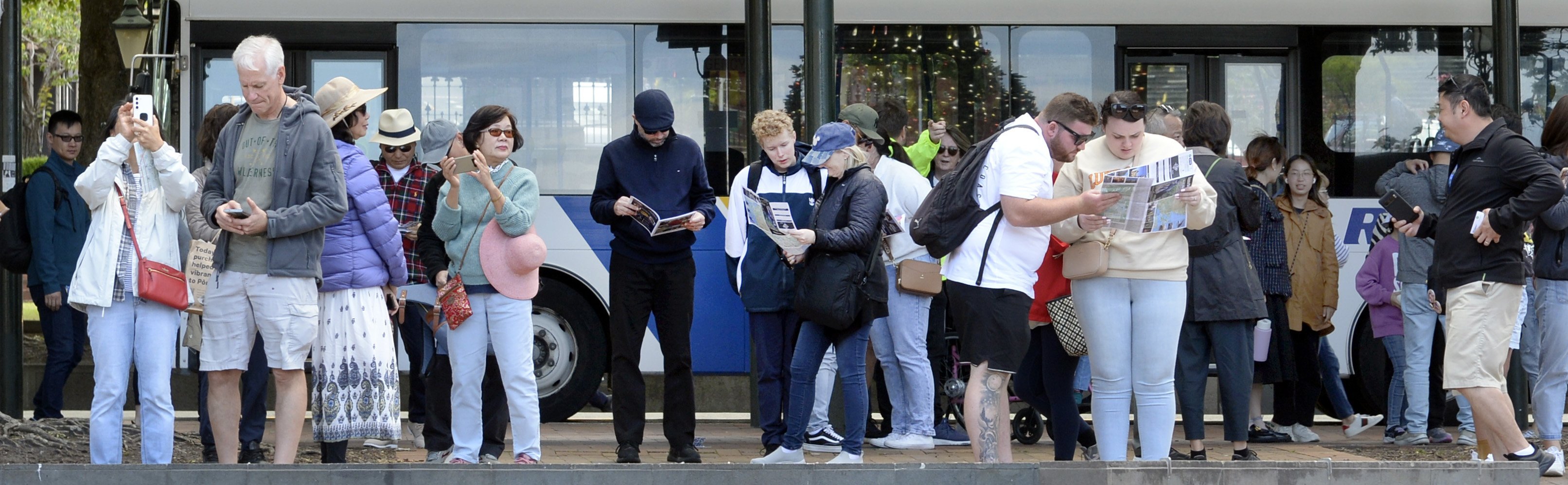 Passengers from the cruise ship get their bearings after being dropped off by the bus in the...