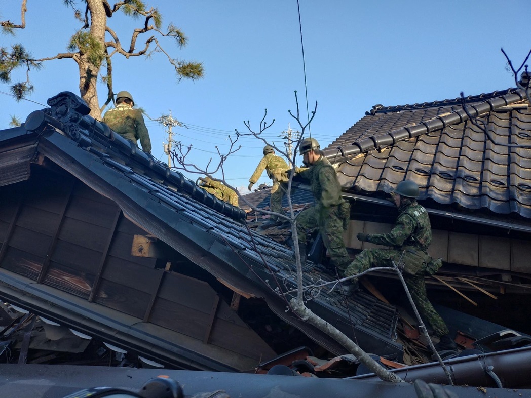 Soldiers conduct rescue operations at a collapsed house in Wajima, Ishikawa prefecture, following...