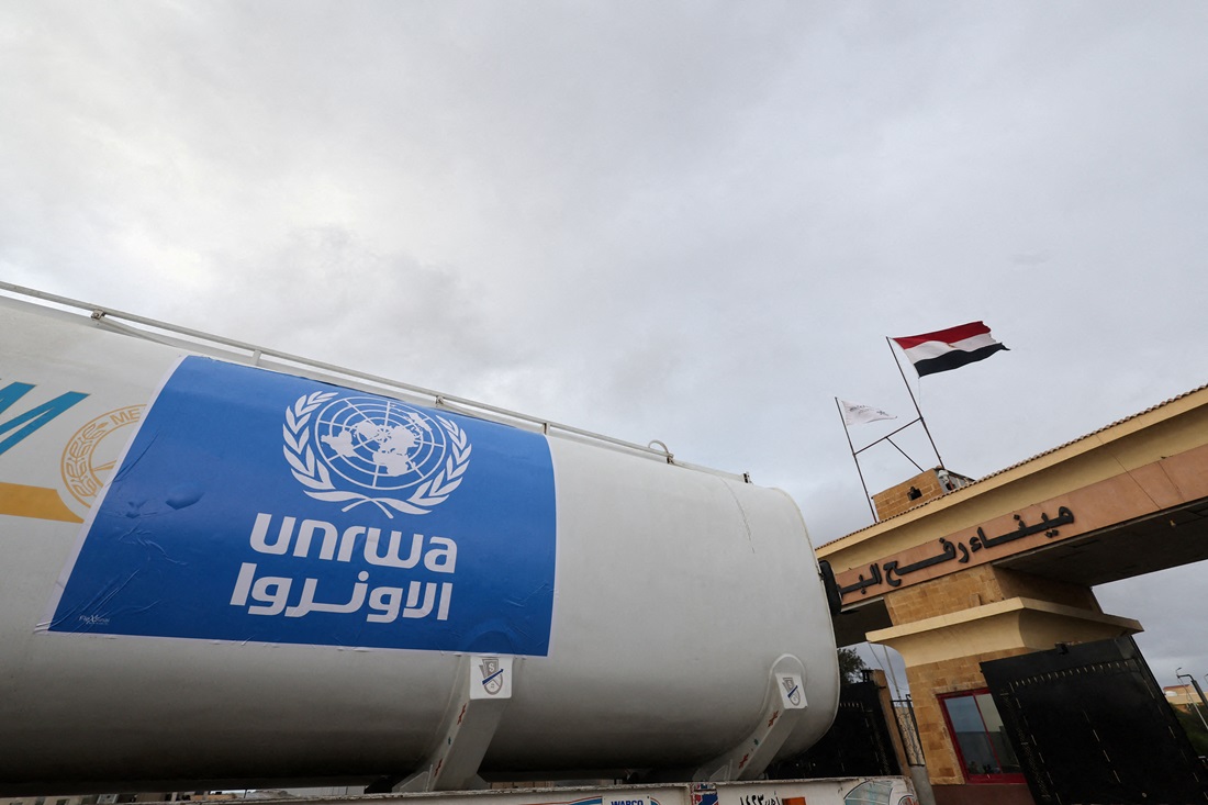 A truck marked with the UNRWA logo crosses into Egypt from Gaza, at the Rafah border crossing, in...