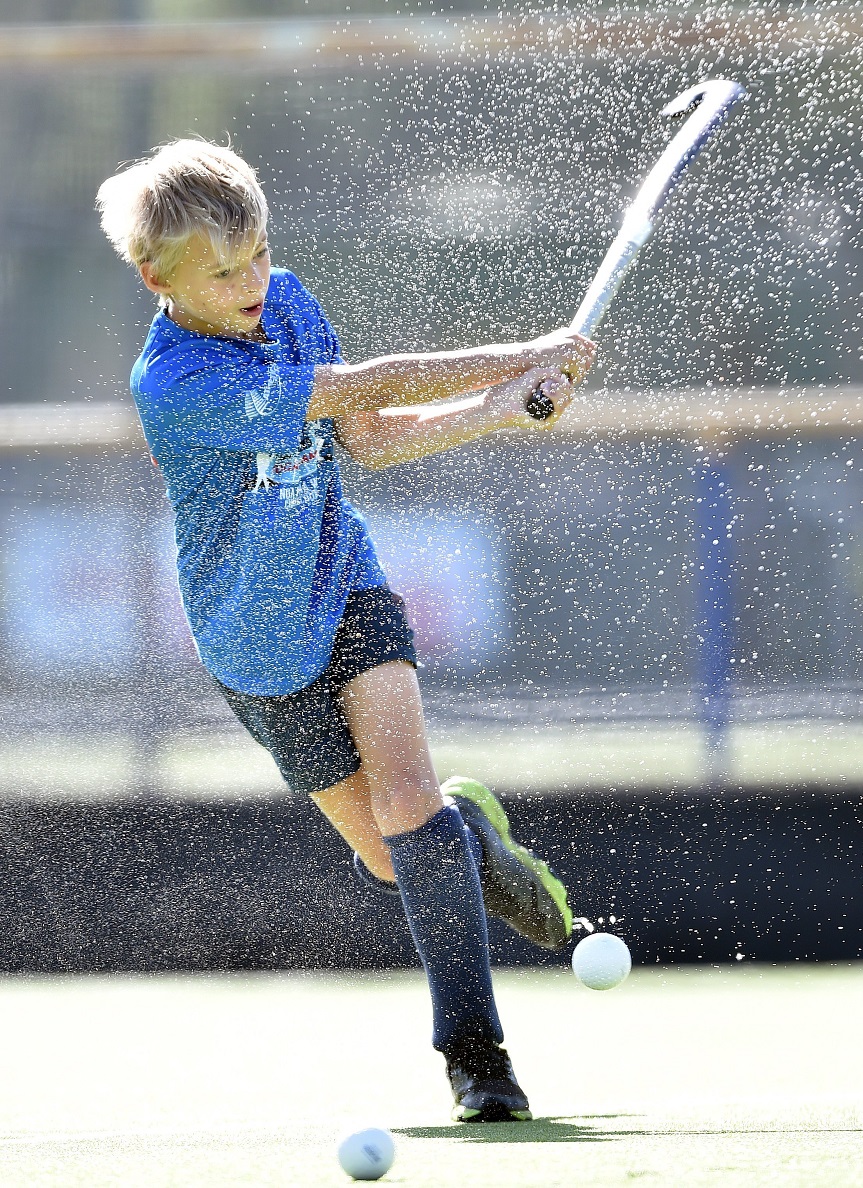 Tom Nichol, 11, covers himself in spray during a Junior Black Sticks coaching session.