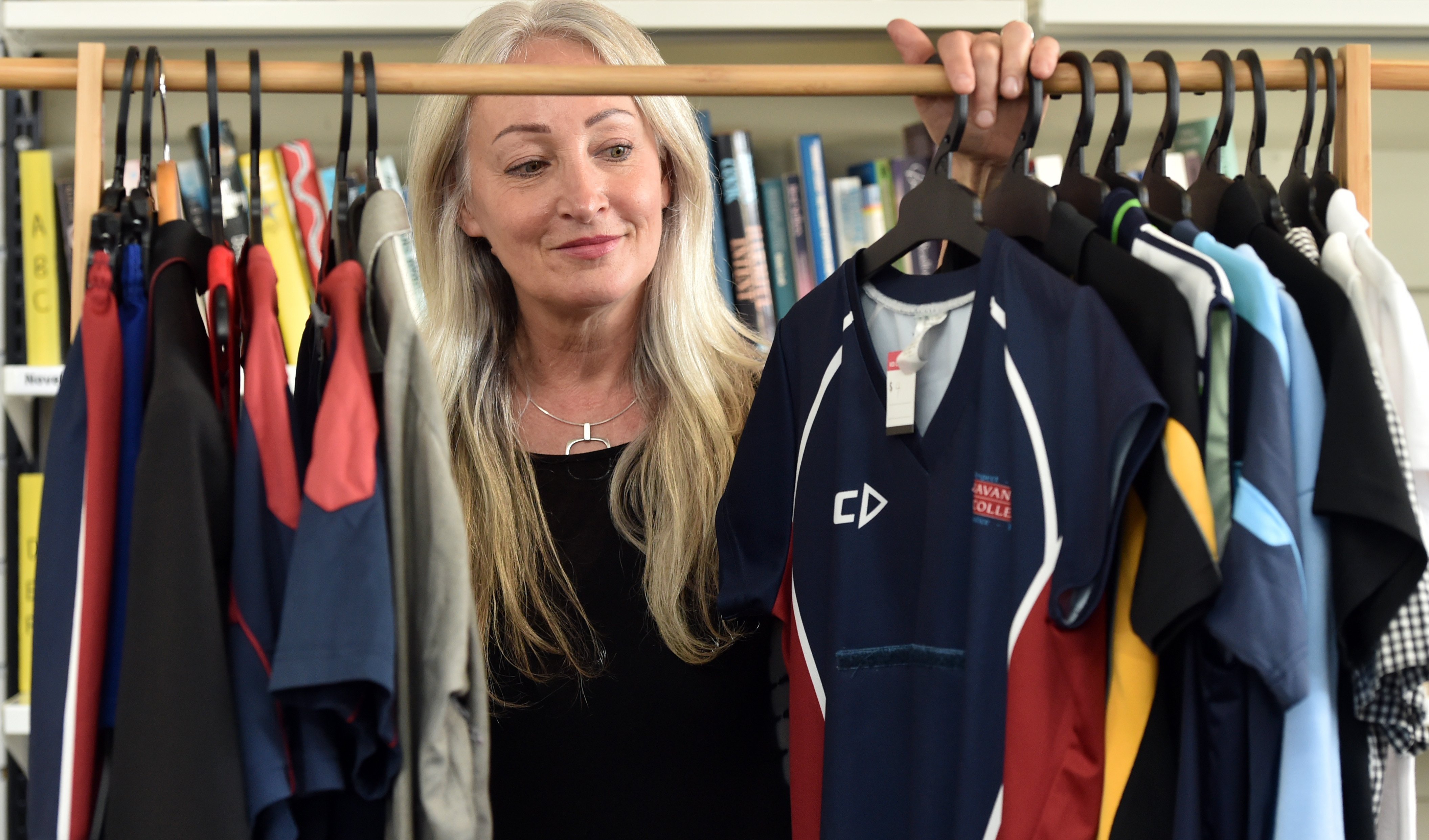 Red Cross Shop assistant manager Tessa Petley looks through the shop’s second-hand school uniform...