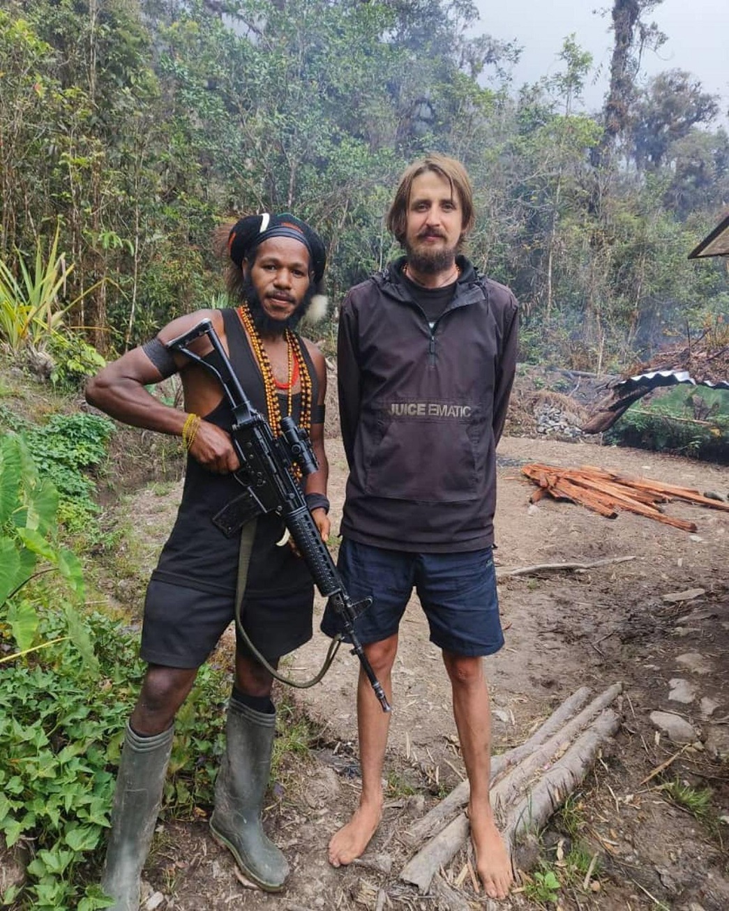 New Zealand pilot Phillip Mehrtens stands with a West Papua National Liberation Army soldier,...