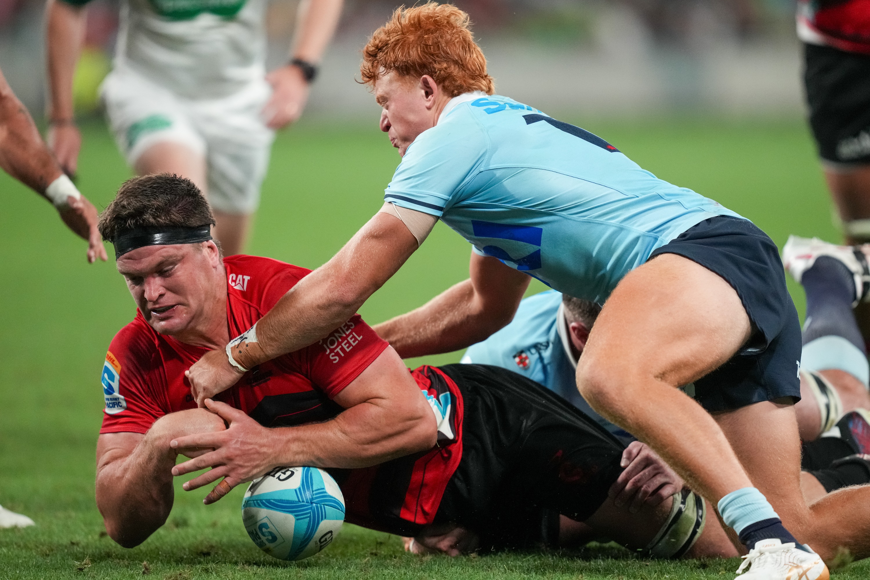 Tane Edmed of the Waratahs (right) tackles Crusader Scott Barrett to deny him try. Photo: Getty...