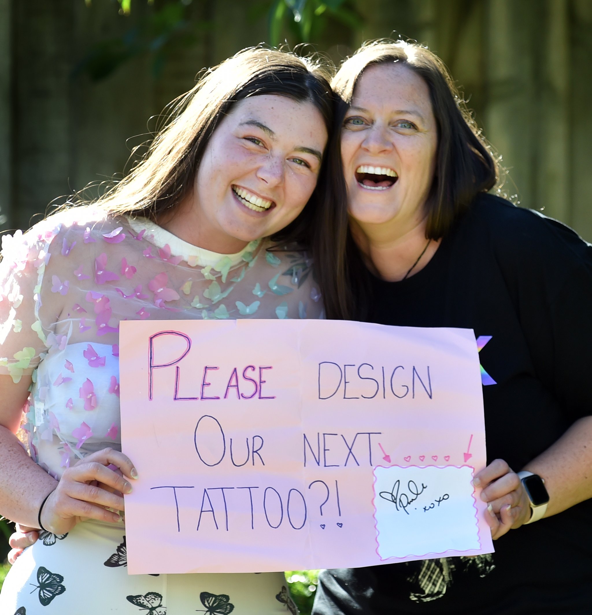 Pink fans Tiana Cresswell (left) and her aunt Bernadette White hold the poster they got Pink to...