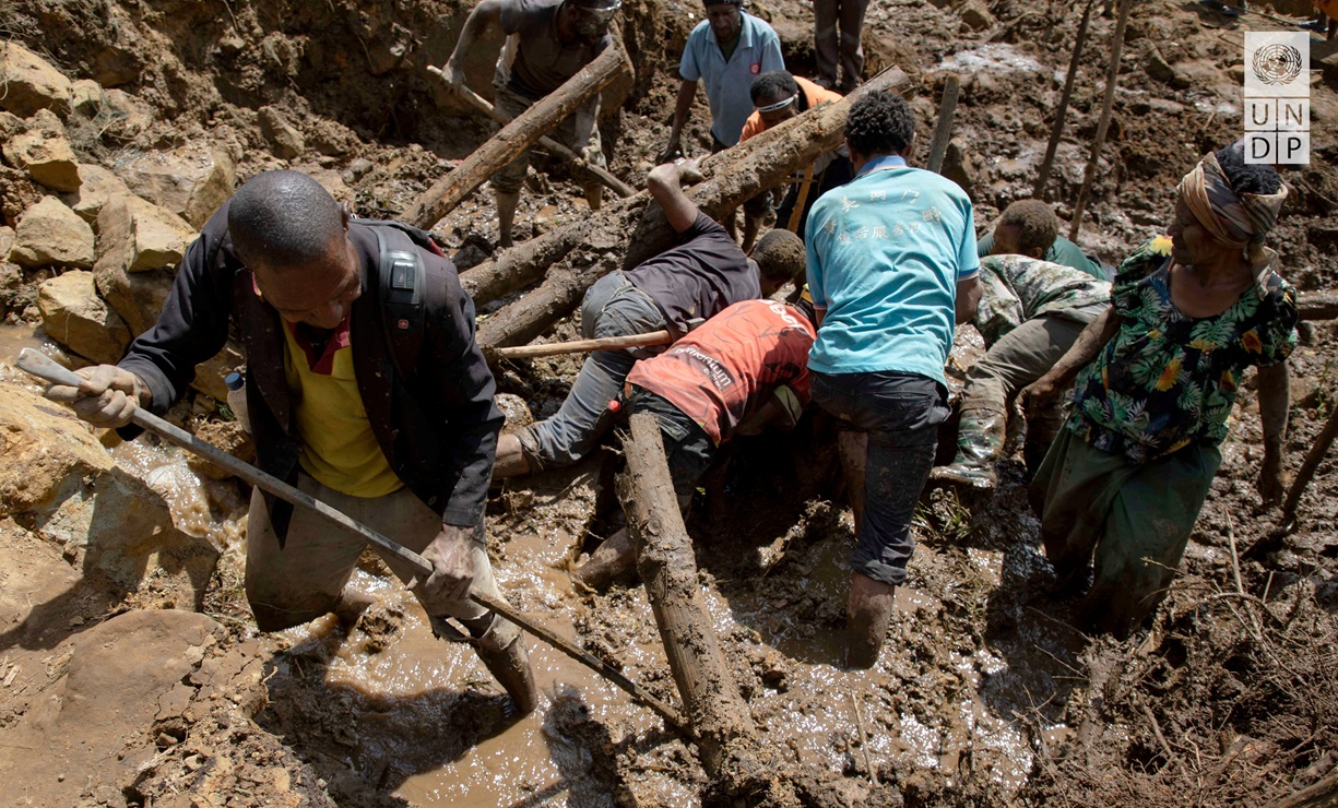 People clear an area at the site of a landslide in Papua New Guinea's Yambali village earlier...