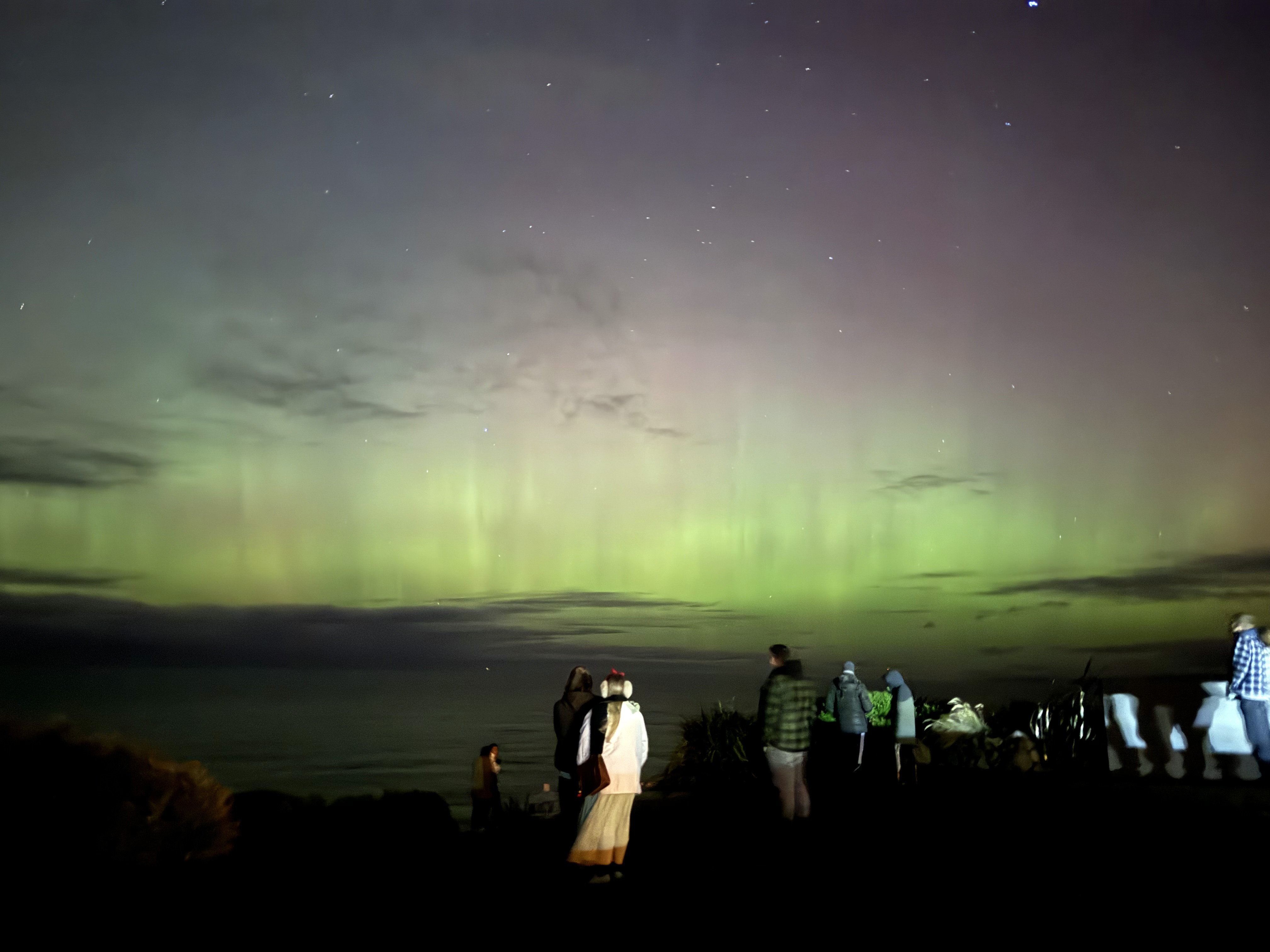 People watch the aurora over the south coast from St Clair, near Cargill’s Castle, about 9.30pm...