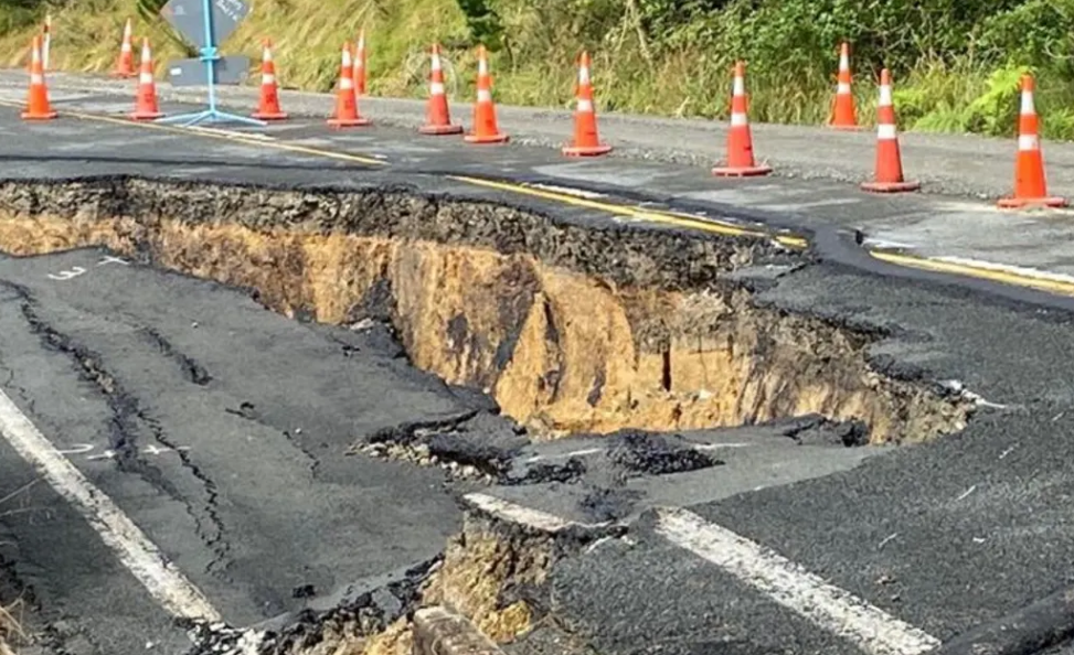 Damage to State Highway 23 with road cones around places where it was cracked and slumped in...