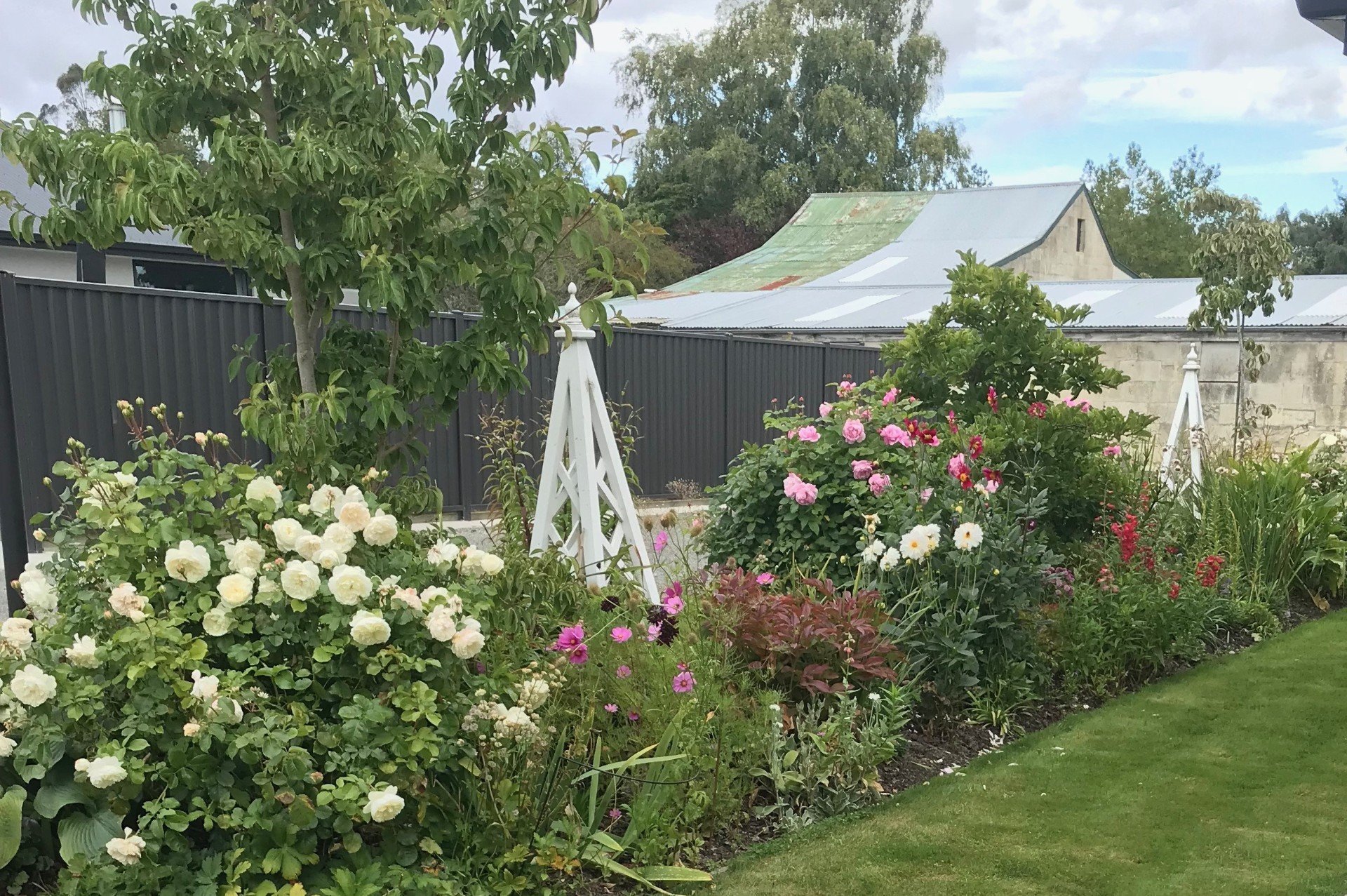 A border of roses and perennials are used instead of a fence.