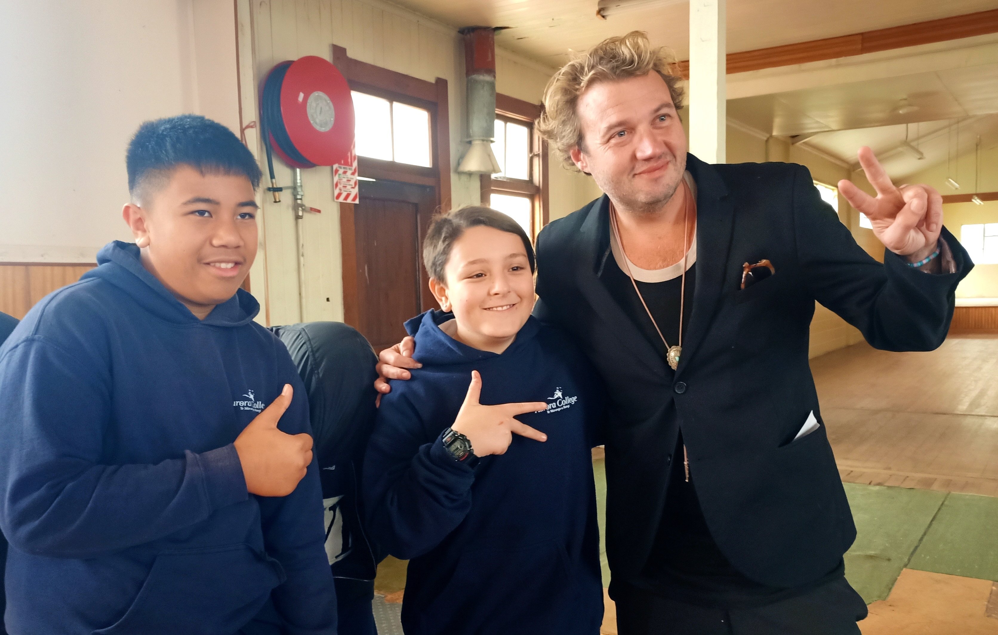 Six60 bassist Chris Mac takes a moment yesterday with Aurora College pupils Joepira Arake (left)...