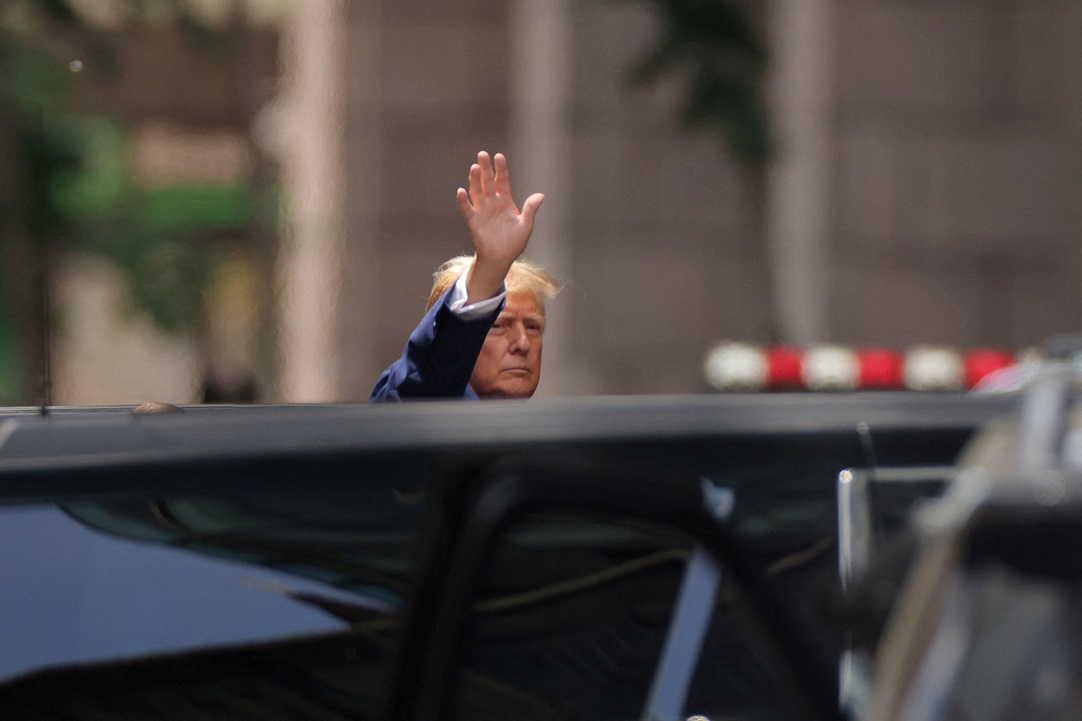 Donald Trump gestures to people outside Trump Tower in New York the day after being found guilty...