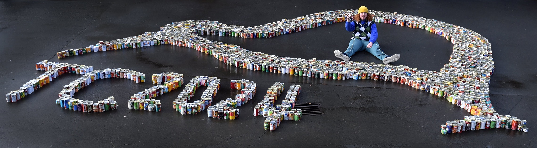 Taieri College pupil Jacob Stephens, 17, sits in a kiwi made of canned donations going to the Kai...