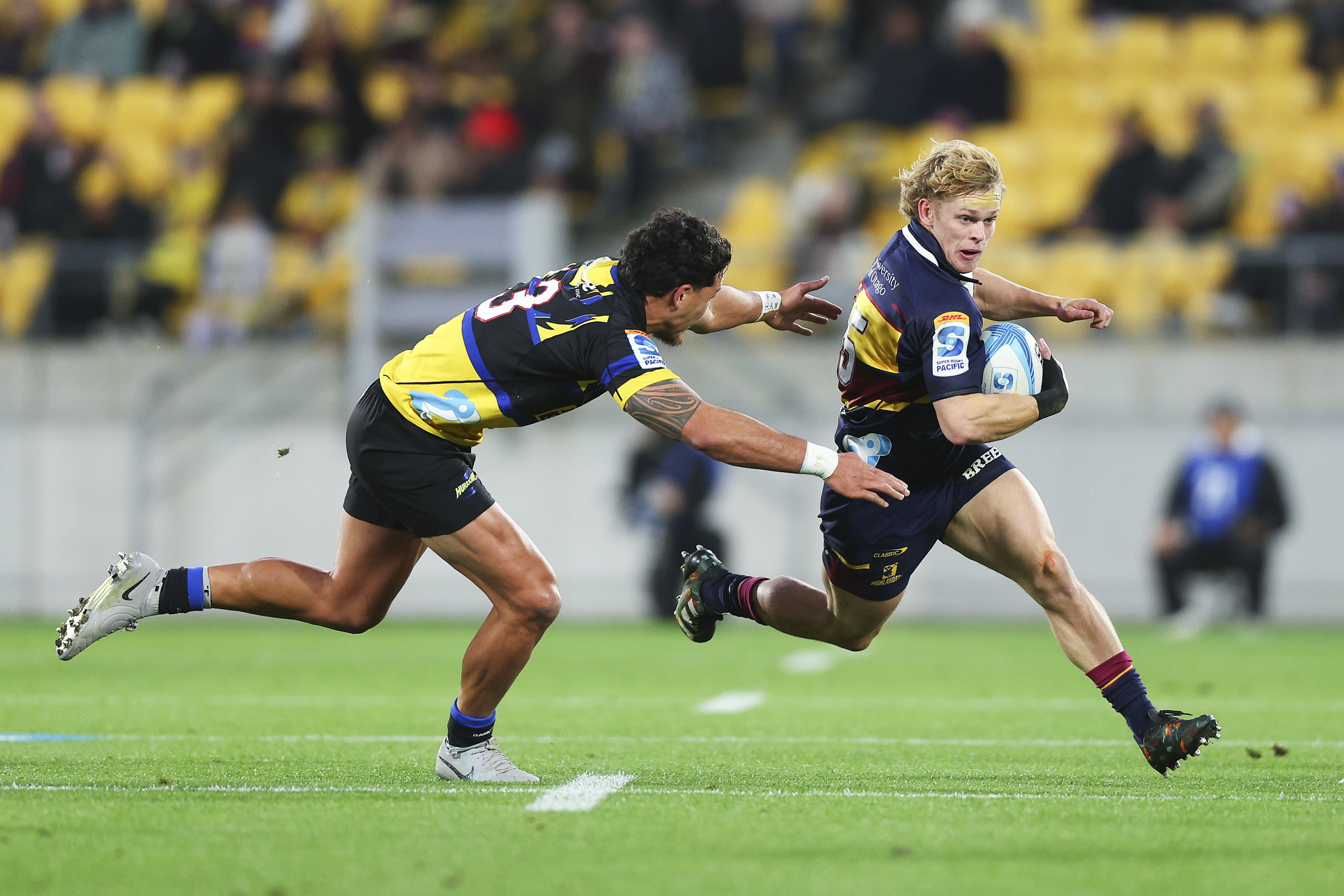 Highlanders fullback Finn Hurley tries to dance around Hurricanes centre Billy Proctor in...