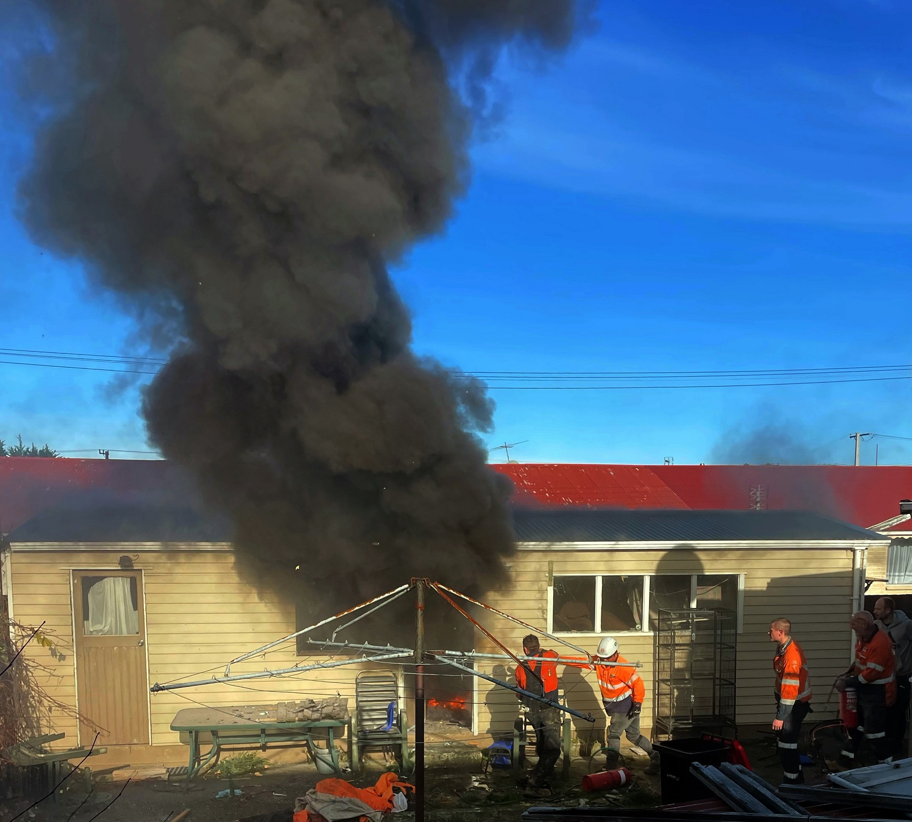 Thick black smoke billows from a garage on a Rona St property yesterday. Photo: Melissa Moana