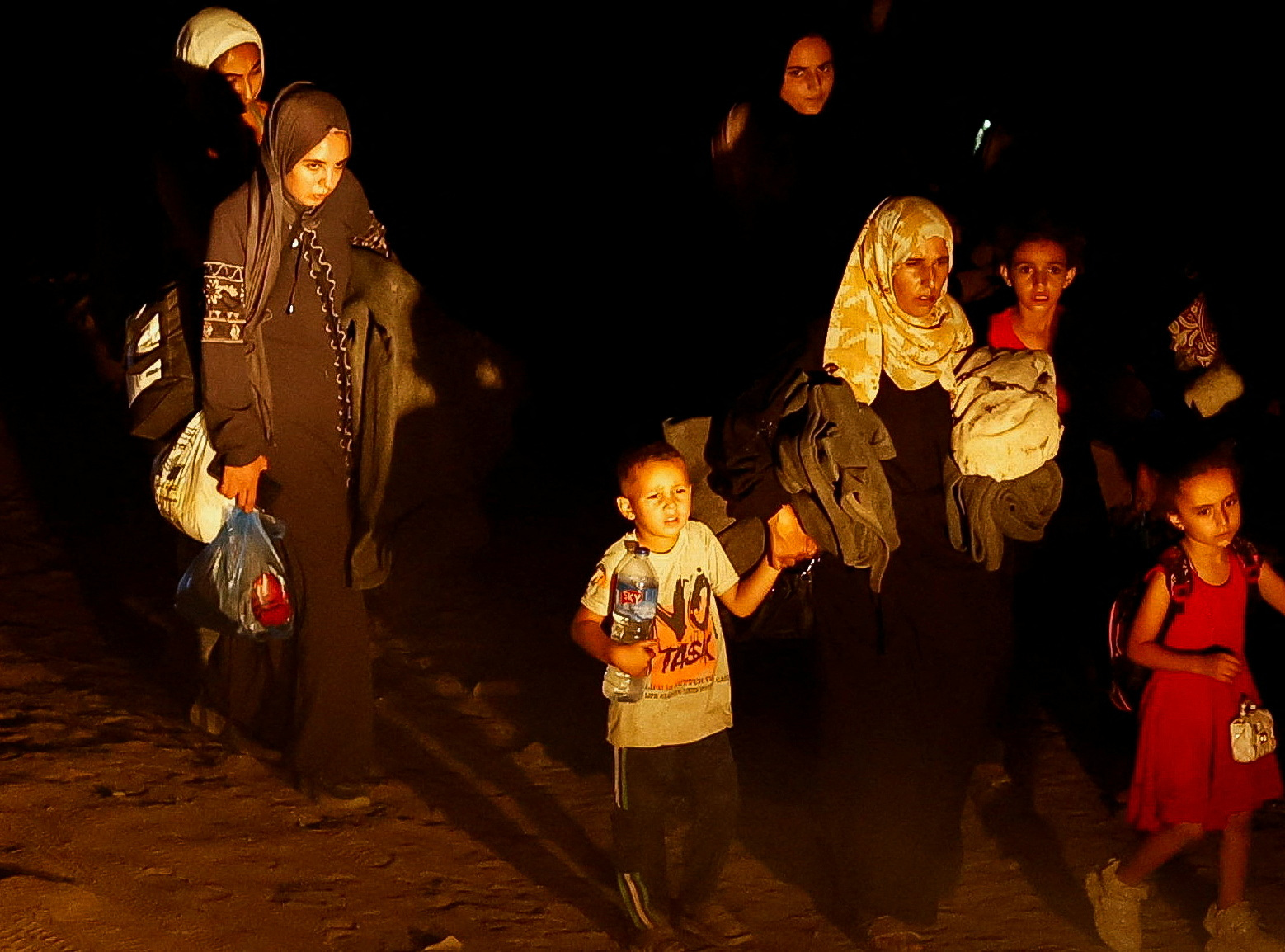 Palestinians who fled the eastern part of Khan Younis walk after they were ordered by the Israeli...