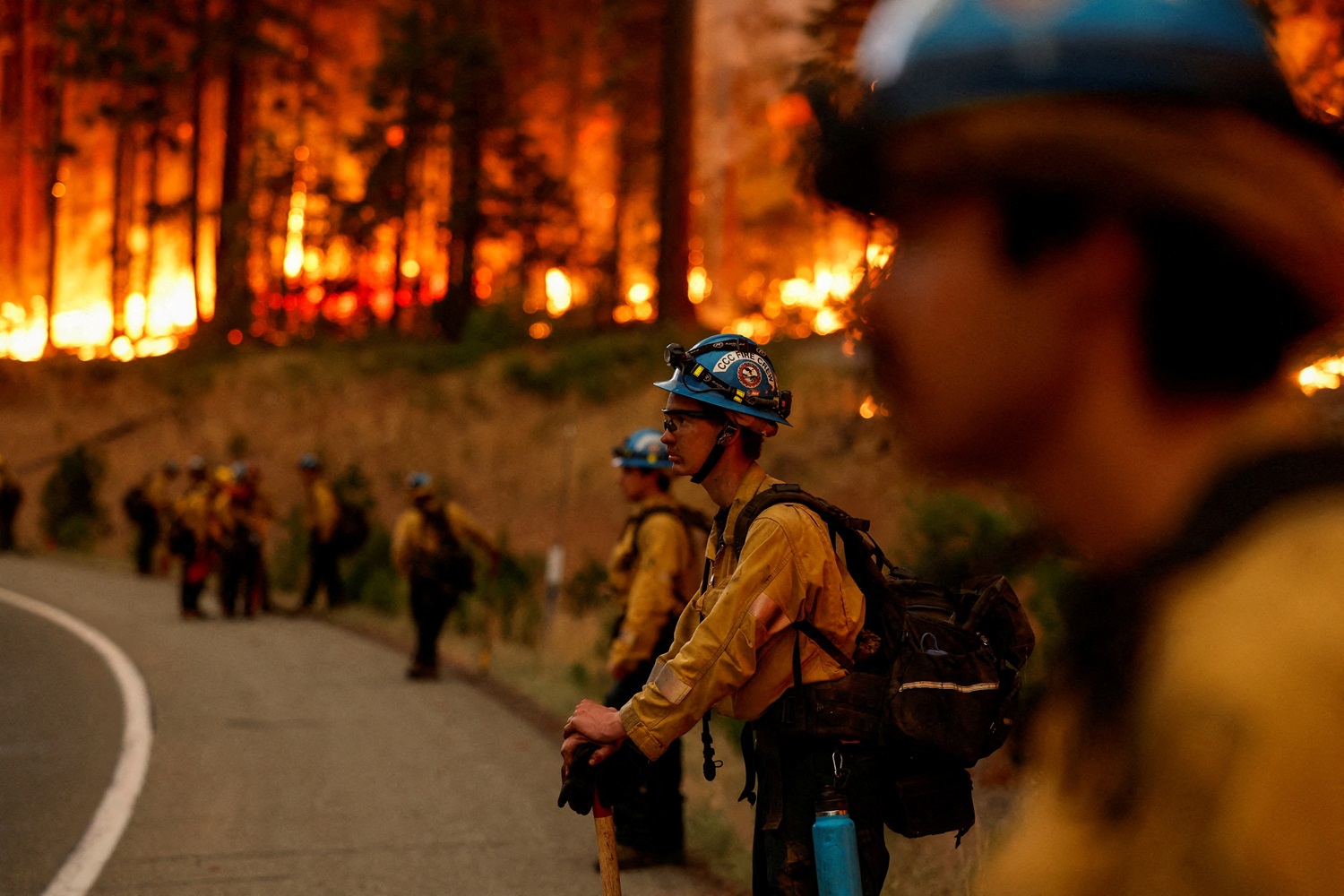 Firefighters stand by the road as the Park Fire burns, near Jonesville, California. Photo: Reuters