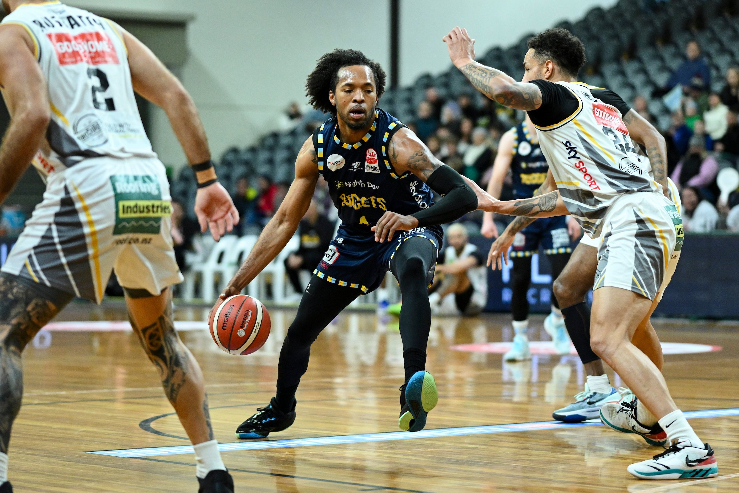 Otago Nuggets forward Kimani Lawrence looks for a way past Franklin Bulls defenders Ethan...