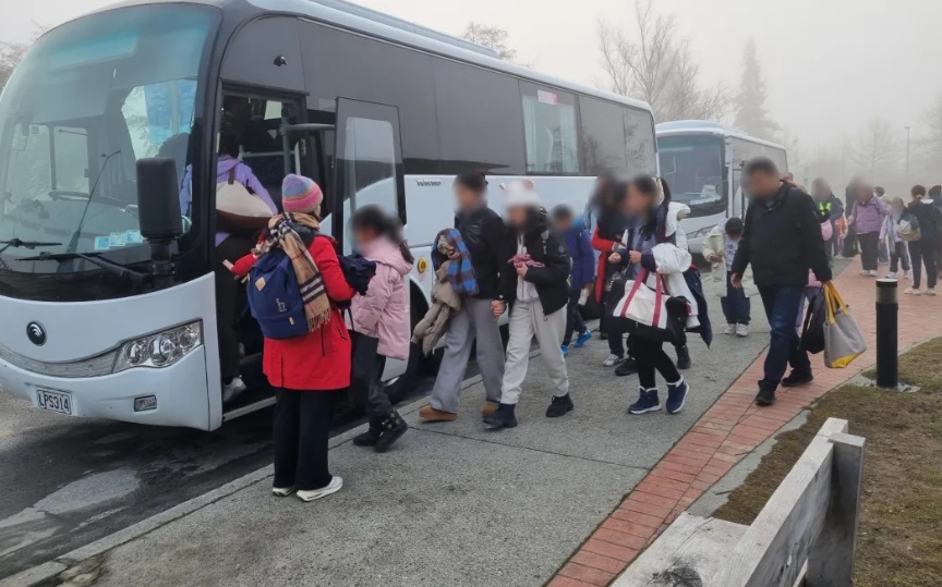 People involved in the Tekapo bus crashes leave Twizel Events Centre on new buses today. Photo: RNZ