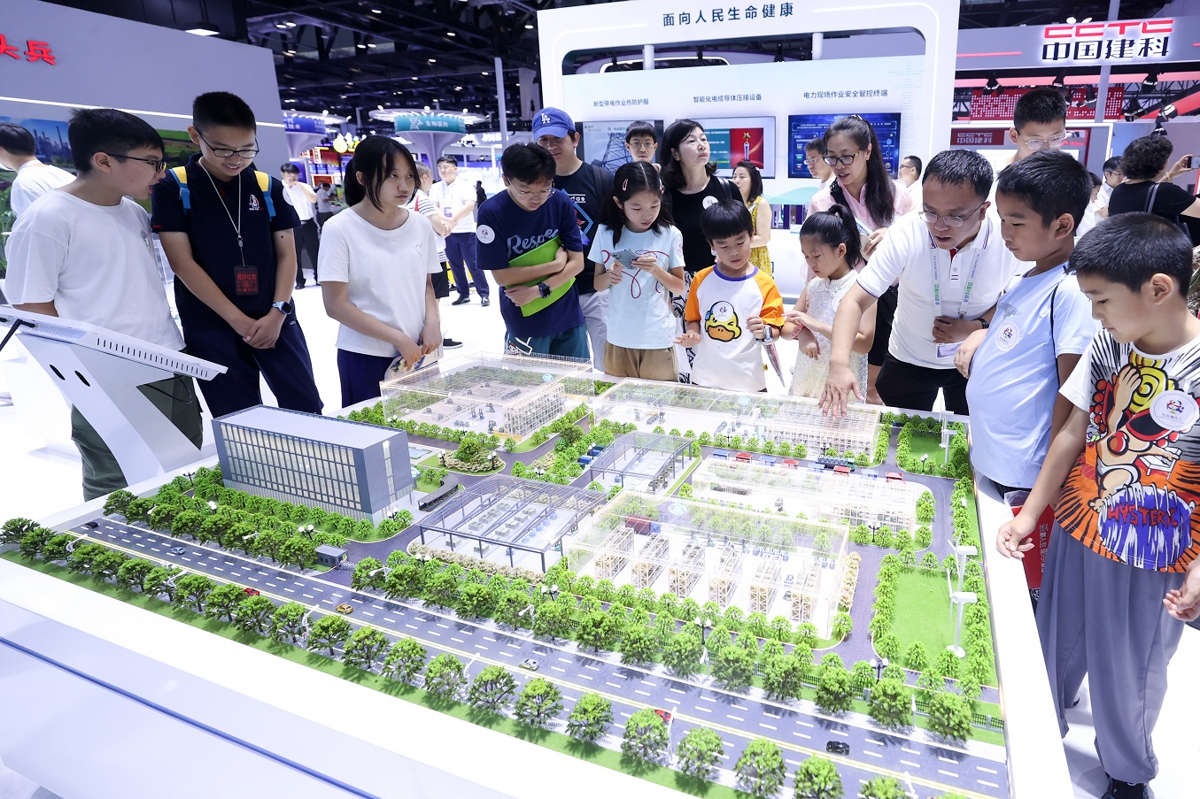 Visitors view a smart park model of State Grid Tianjin Electric Power at the 26th China Beijing...