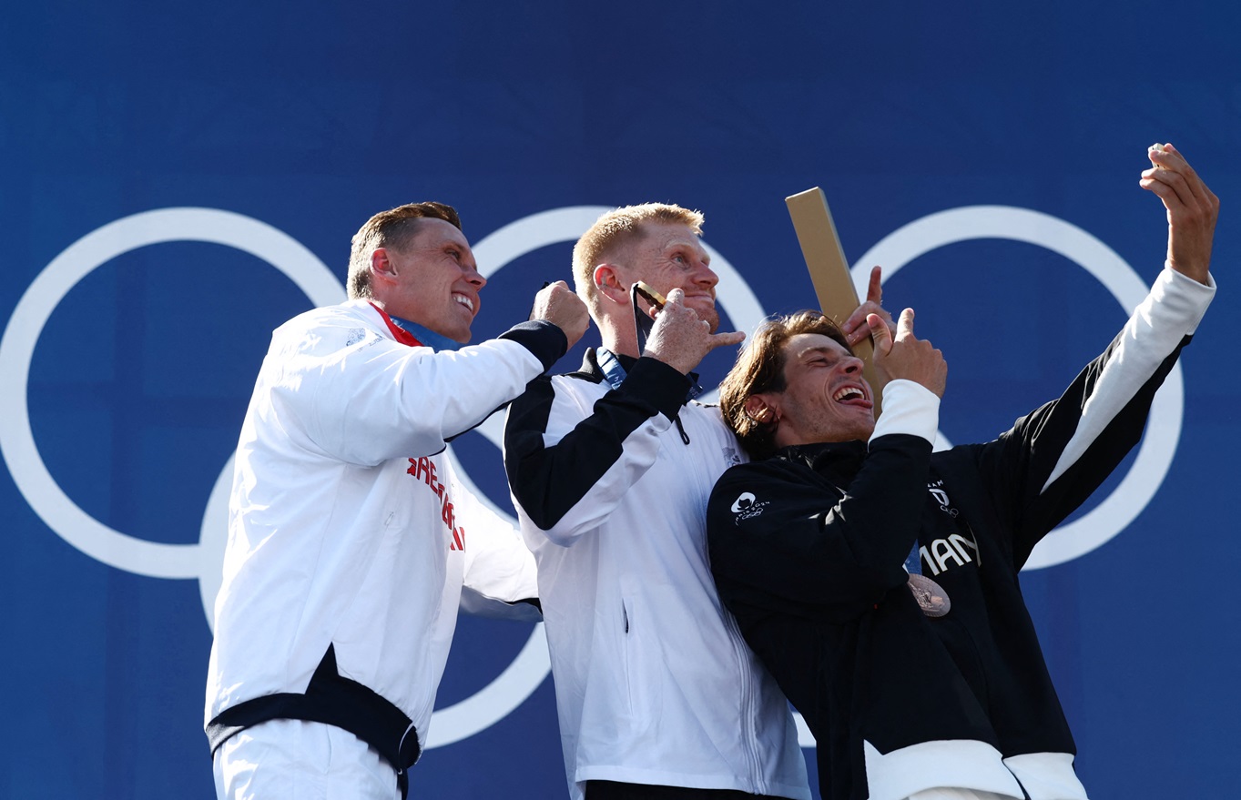 New Zealand's Finn Butcher (1st) poses on the podium with Britain's Joseph Clarke (2nd) and...