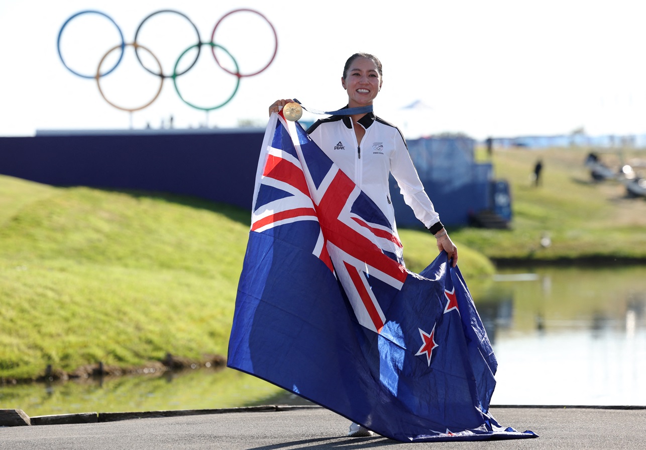 Lydia Ko poses with her gold medal and the New Zealand flag as she celebrates her Olympic victory...