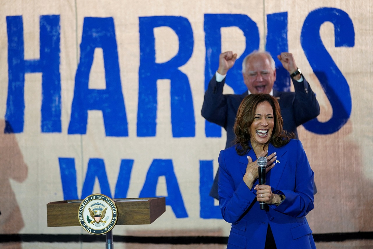 Democratic vice presidential candidate Tim Walz cheers US Vice President Kamala Harris while she...