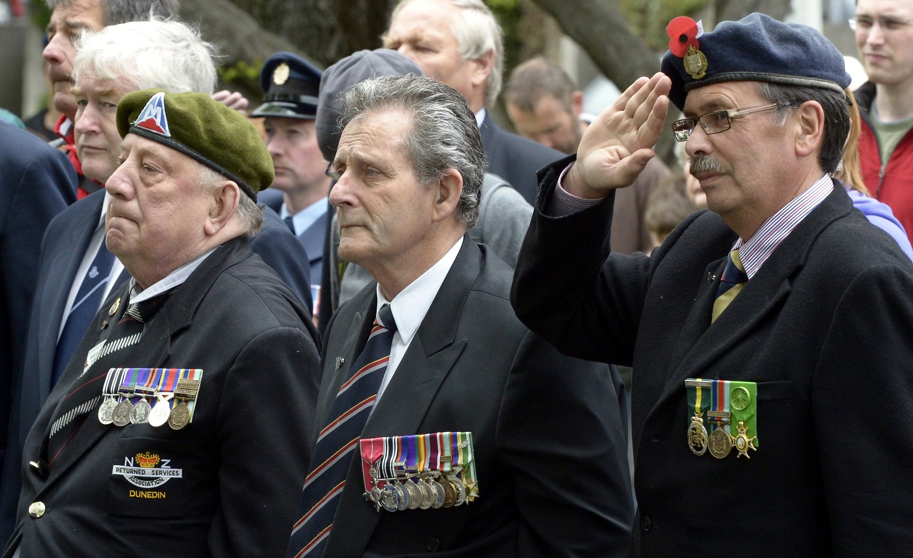 Veterans (from left) David Ellison, Fred Daniel and John Broughton stand at attention during the...