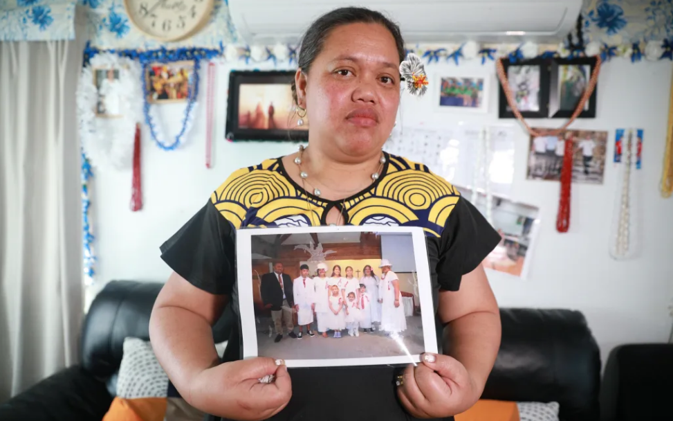 Nu'ulua Fa'aofo stands in her Kelston home holding a photo of her family after her husband, Uili...