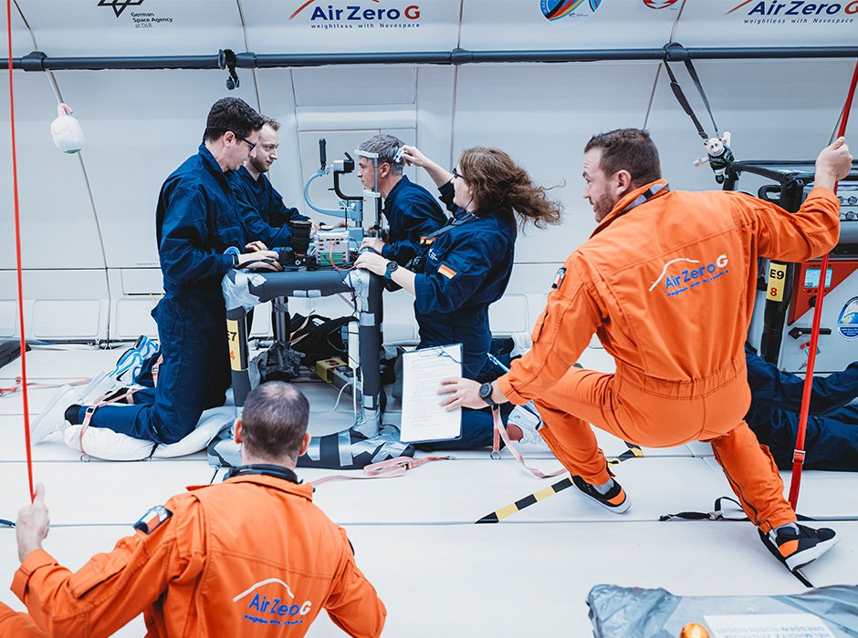 Ophthalmologist researchers study a patient’s eyes while on a parabolic flight that creates short...