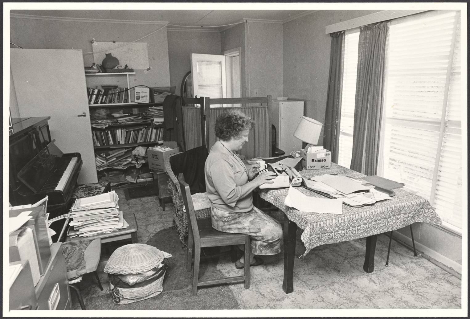 Janet Frame at her desk, Whanganui, 1983. Unidentified photographer, MS-3028/807/004, Hocken...