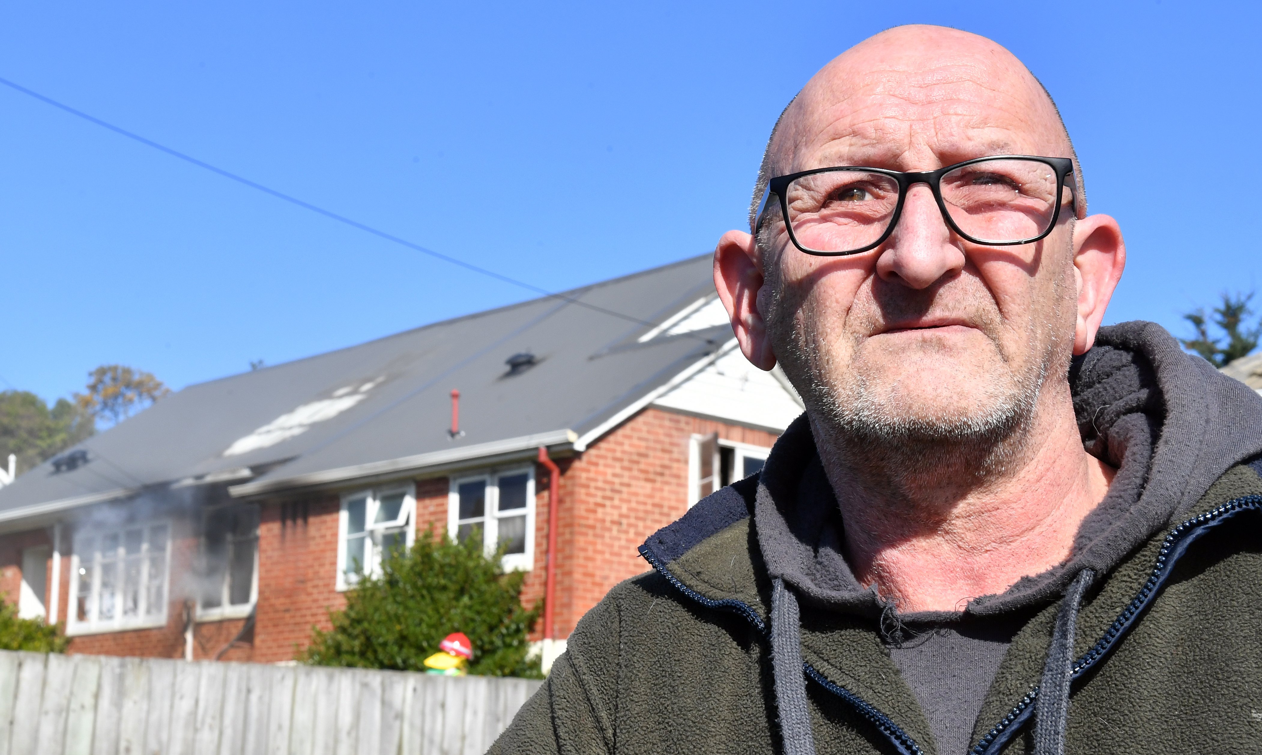 Neighbour Nick Moore helped residents out of a burning house (below) in Waimea Ave, Dunedin,...