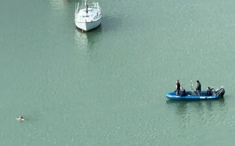 The man swam across the channel to Ōkiato, followed by police in an inflatable boat. Photo: Supplied