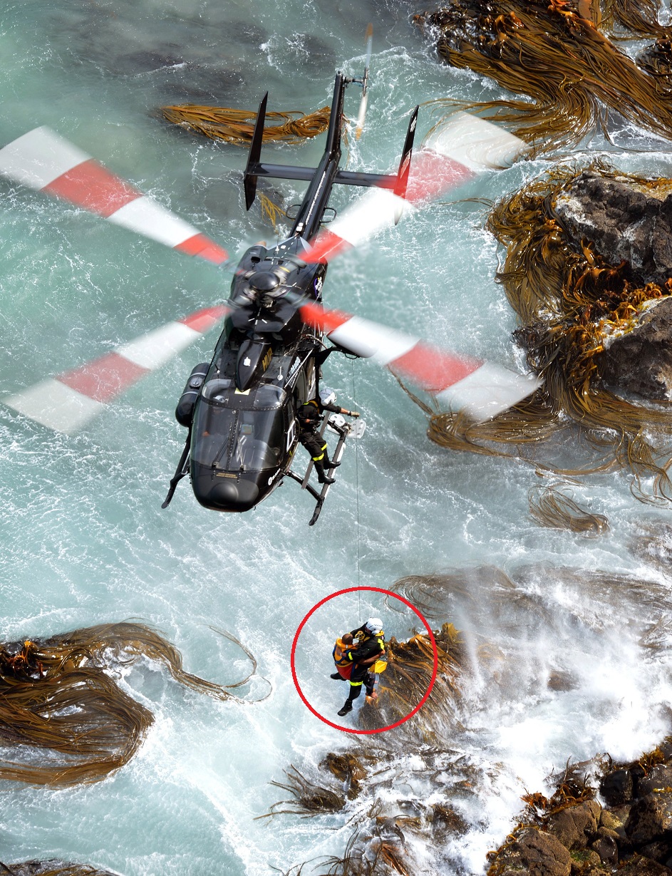 Otago Regional Rescue pilot Clayton Girvan holds the helicopter above surging surf as an injured...