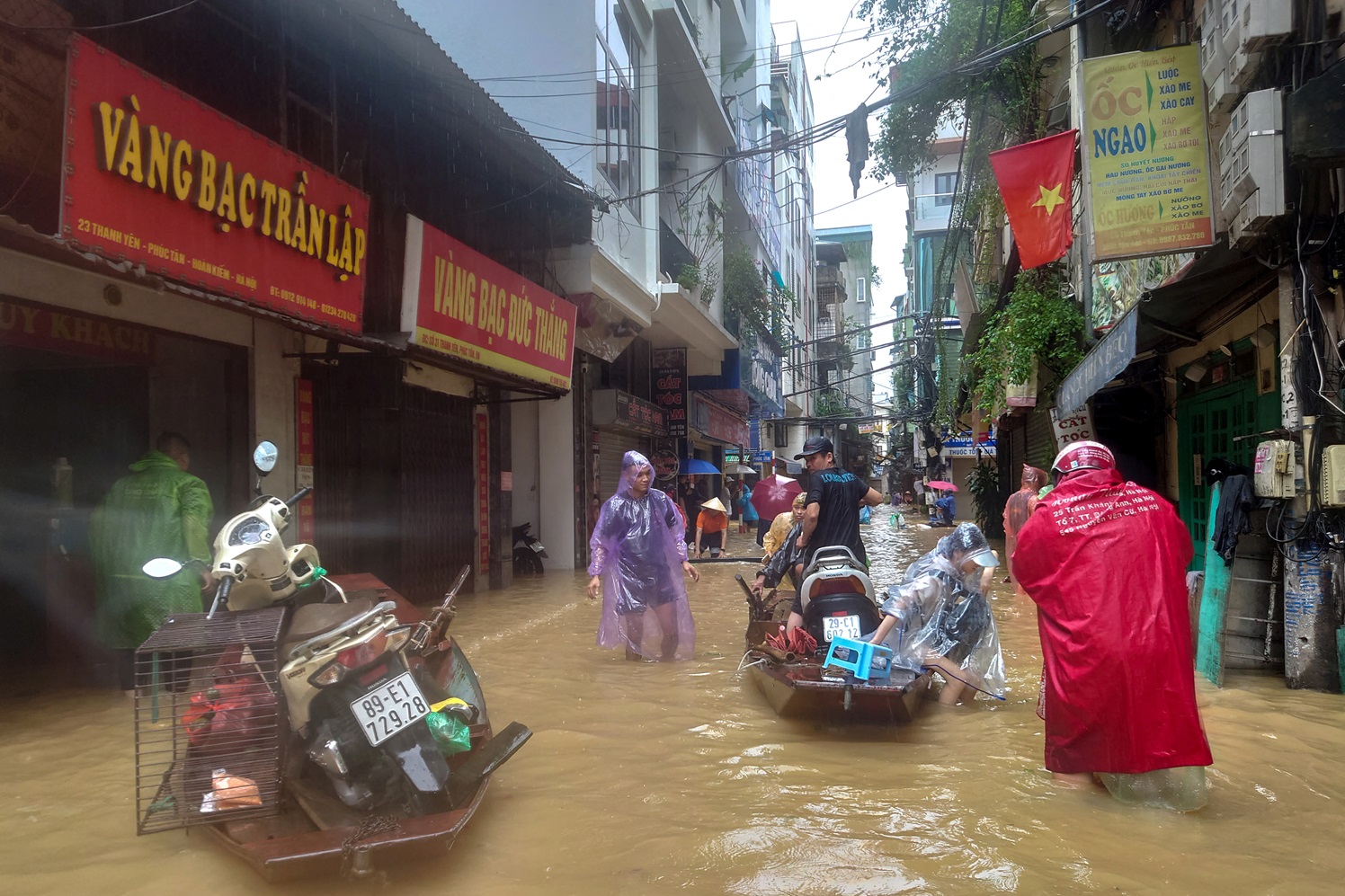 People wade through a flooded street in Hanoi following the impact of Typhoon Yagi. Photo: Reuters