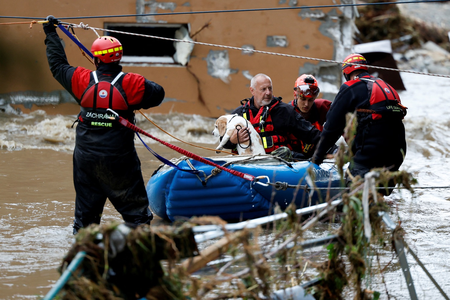 A man holds a dog as he is aided by rescuers on a flooded street in Jesenik, Czech Republic....