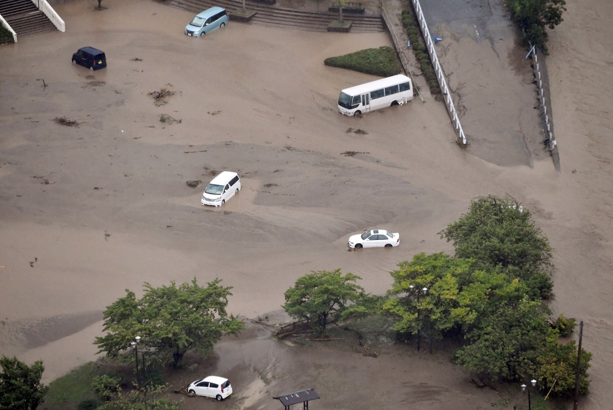 An aerial view shows submerged cars at the parking space of the city government office in Wajima,...