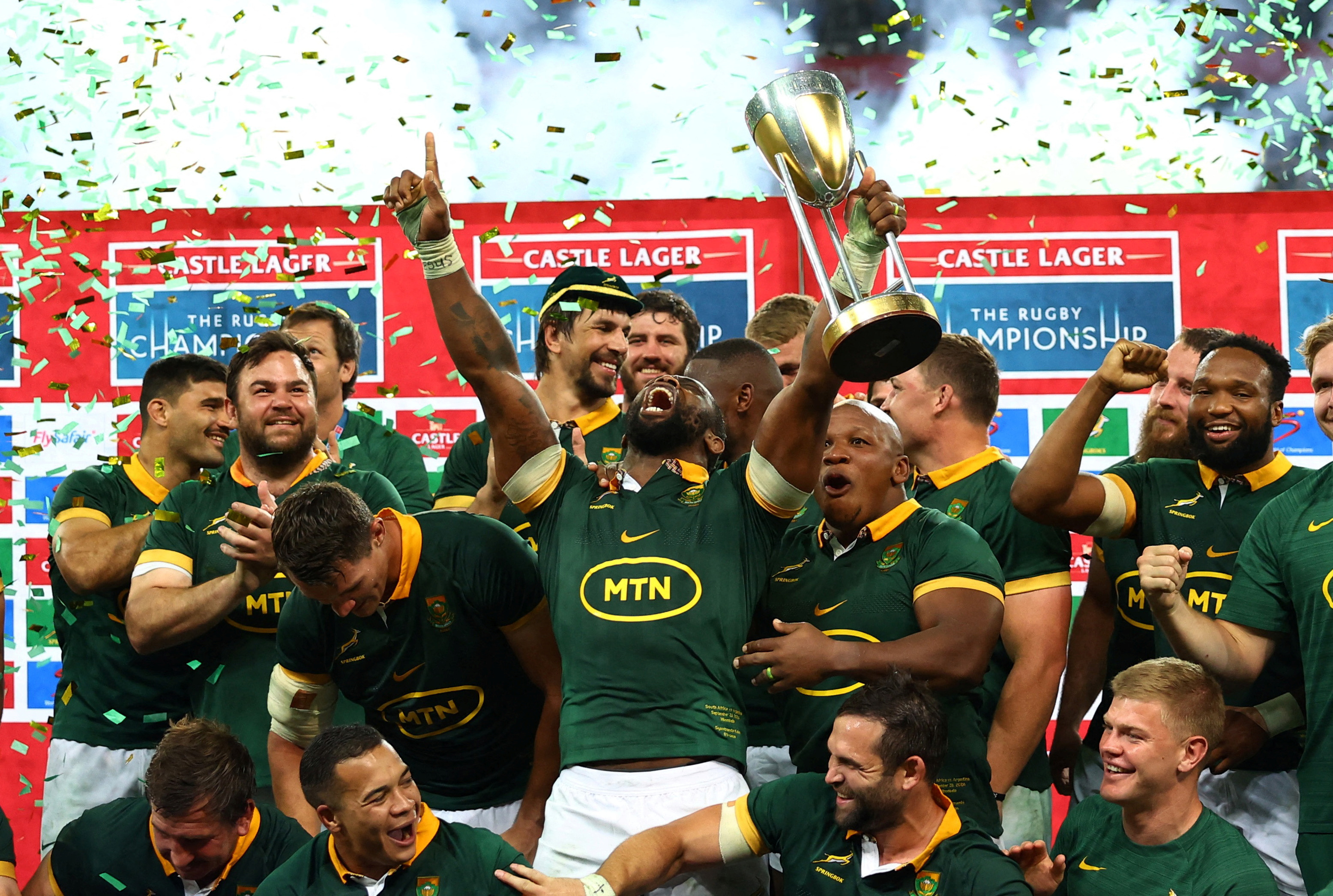 South Africa's Siya Kolisi celebrates with the trophy and teammates after winning the Rugby...