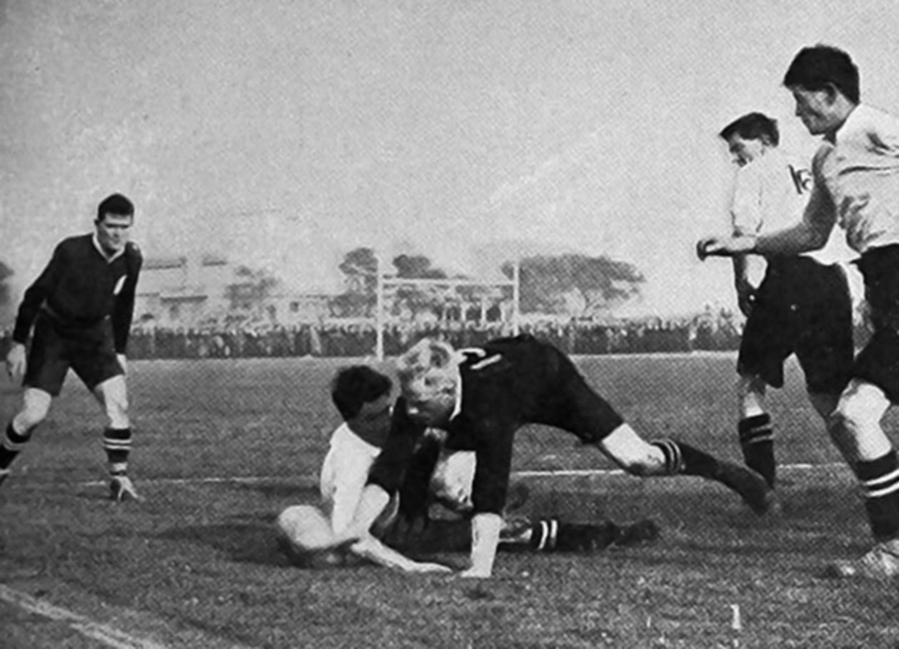 All Blacks halfback Bill Dalley gets the ball from the Swansea three-quarter in a match won by...