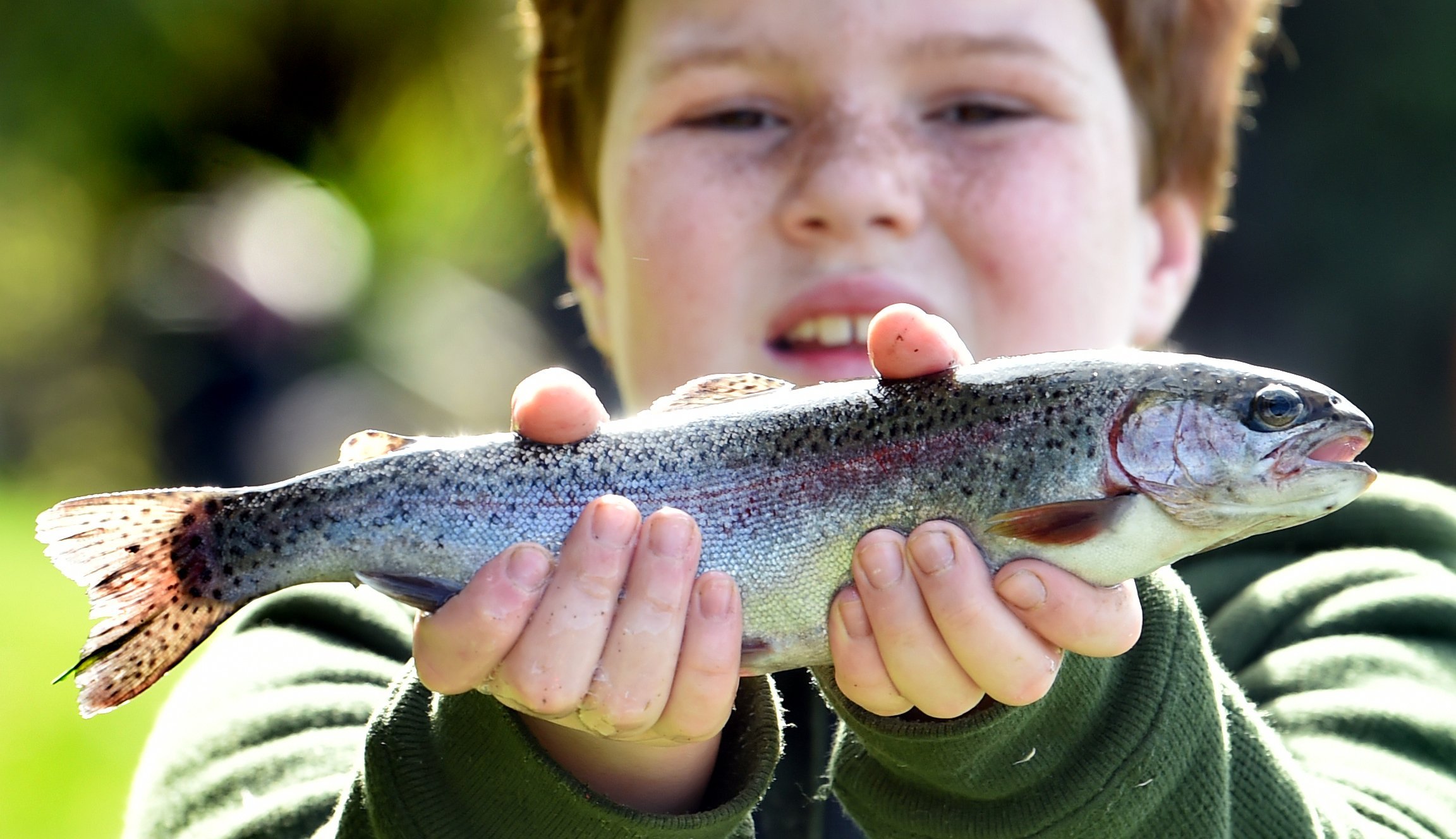 Charlie Dixie, 9, shows off a rainbow trout he caught at Fish & Game’s Take A Kid Fishing event...