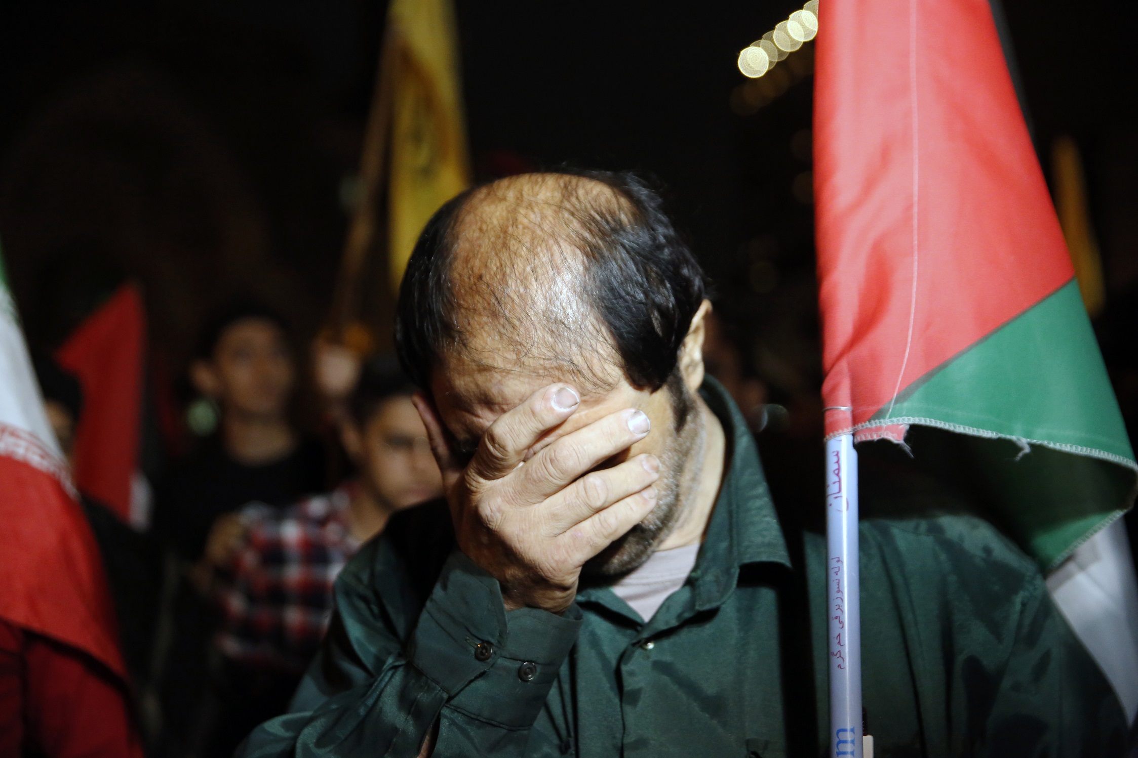 An Iranian demonstrator reacts while hearing news from Beirut during a gathering in Tehran. Photo...