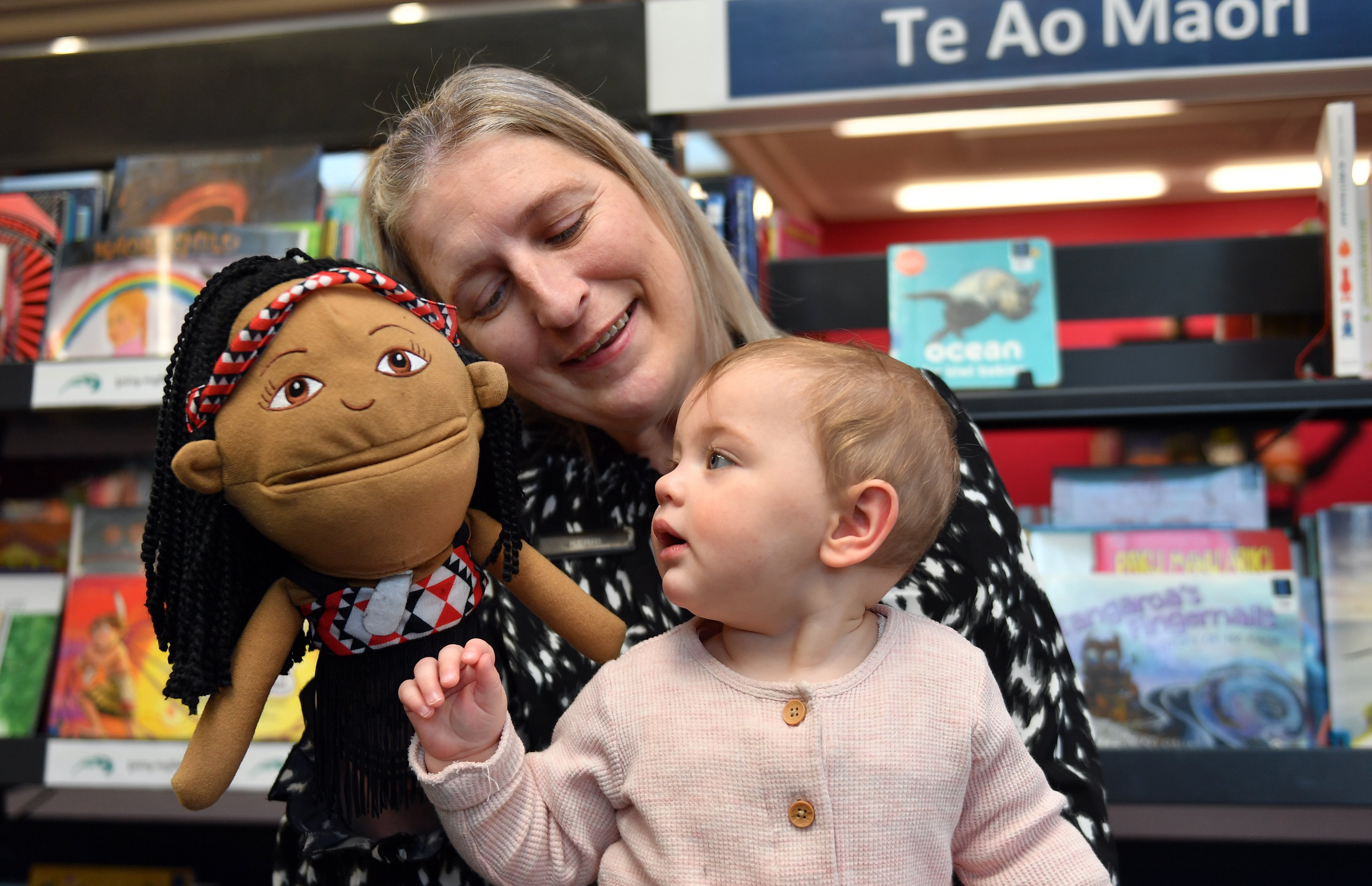 Mosgiel Library librarian assistant Kerri Hayes holds 9-month-old Lyra Parata-Mercer and a Māori...